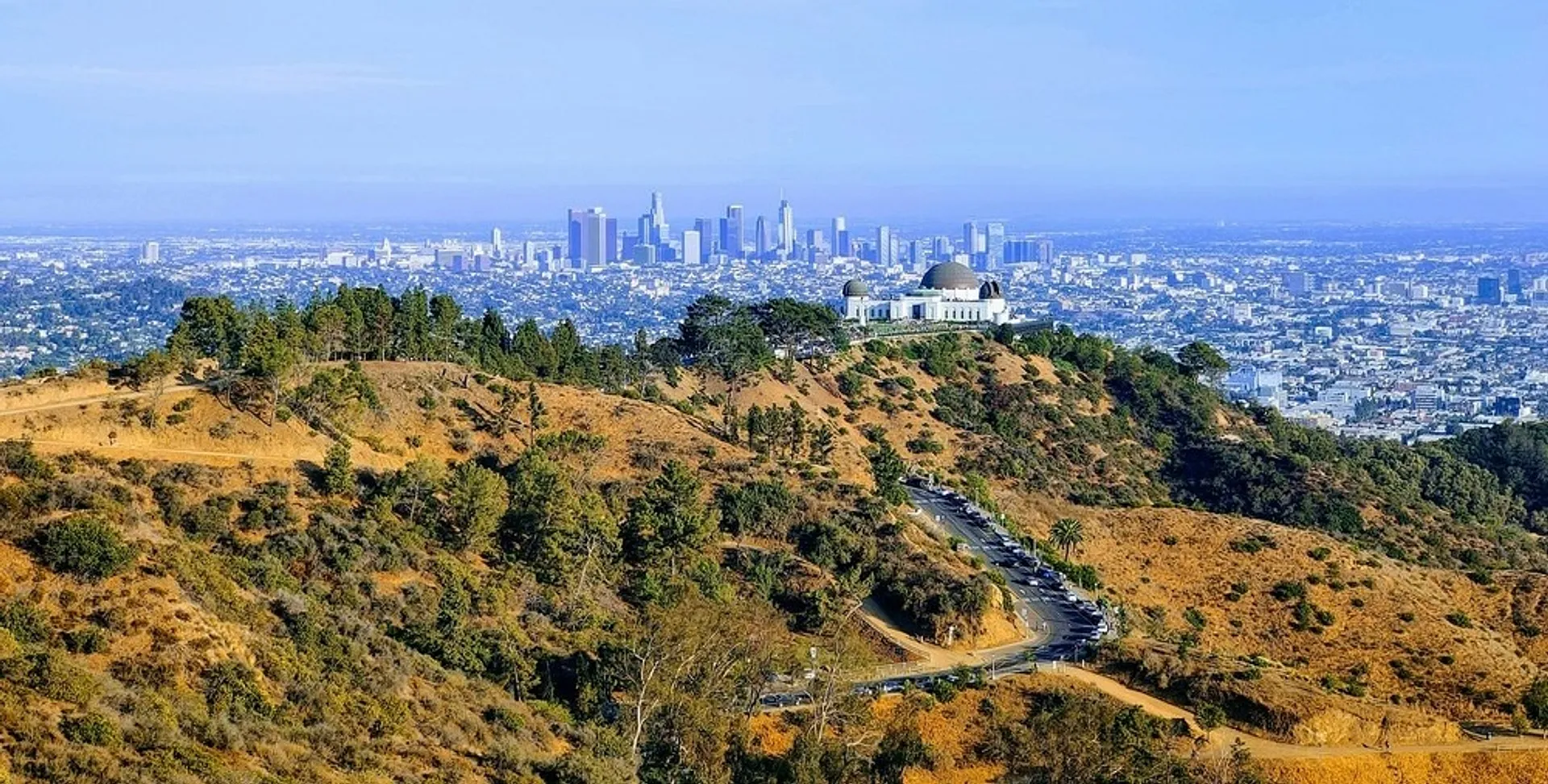 Griffith Observatory overlooks the sprawling cityscape of Los Angeles with its iconic skyline in the background.