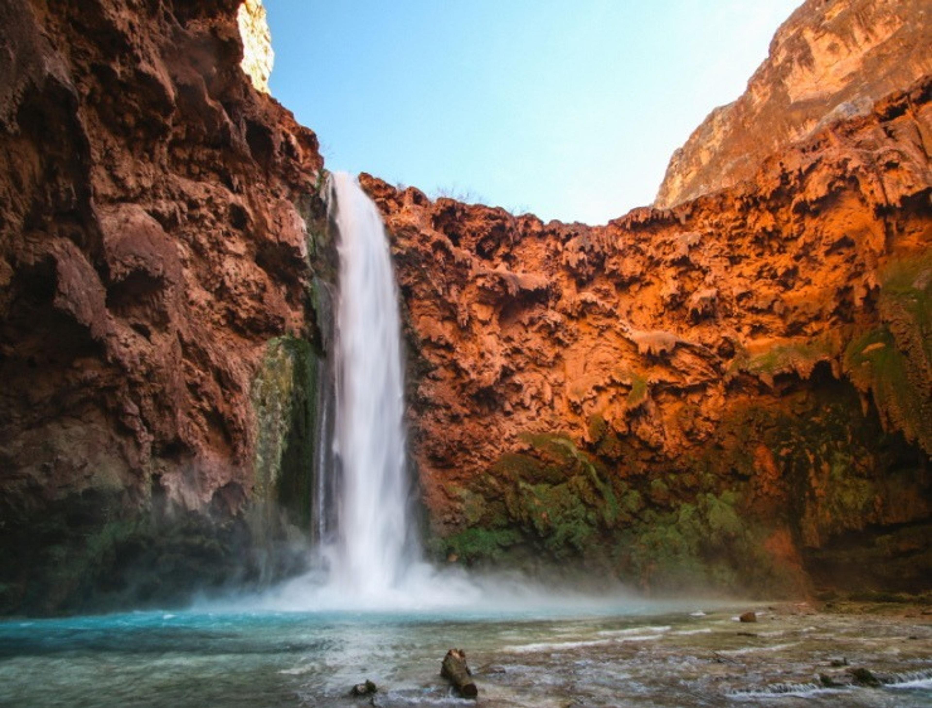 Havasu Falls in Arizona displays its stunning cascade against vibrant red rock cliffs.