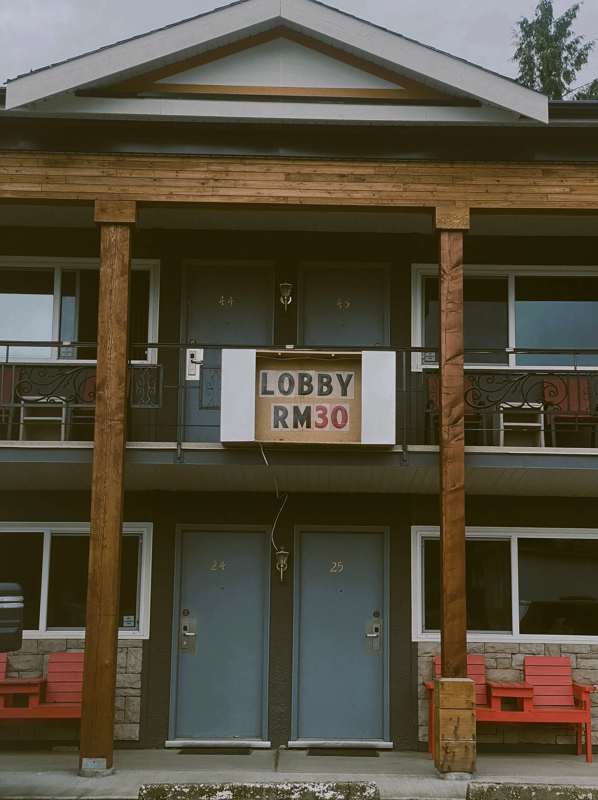 A motel mith a makeshift lobby sign out of cardboard: Lobby Room 30