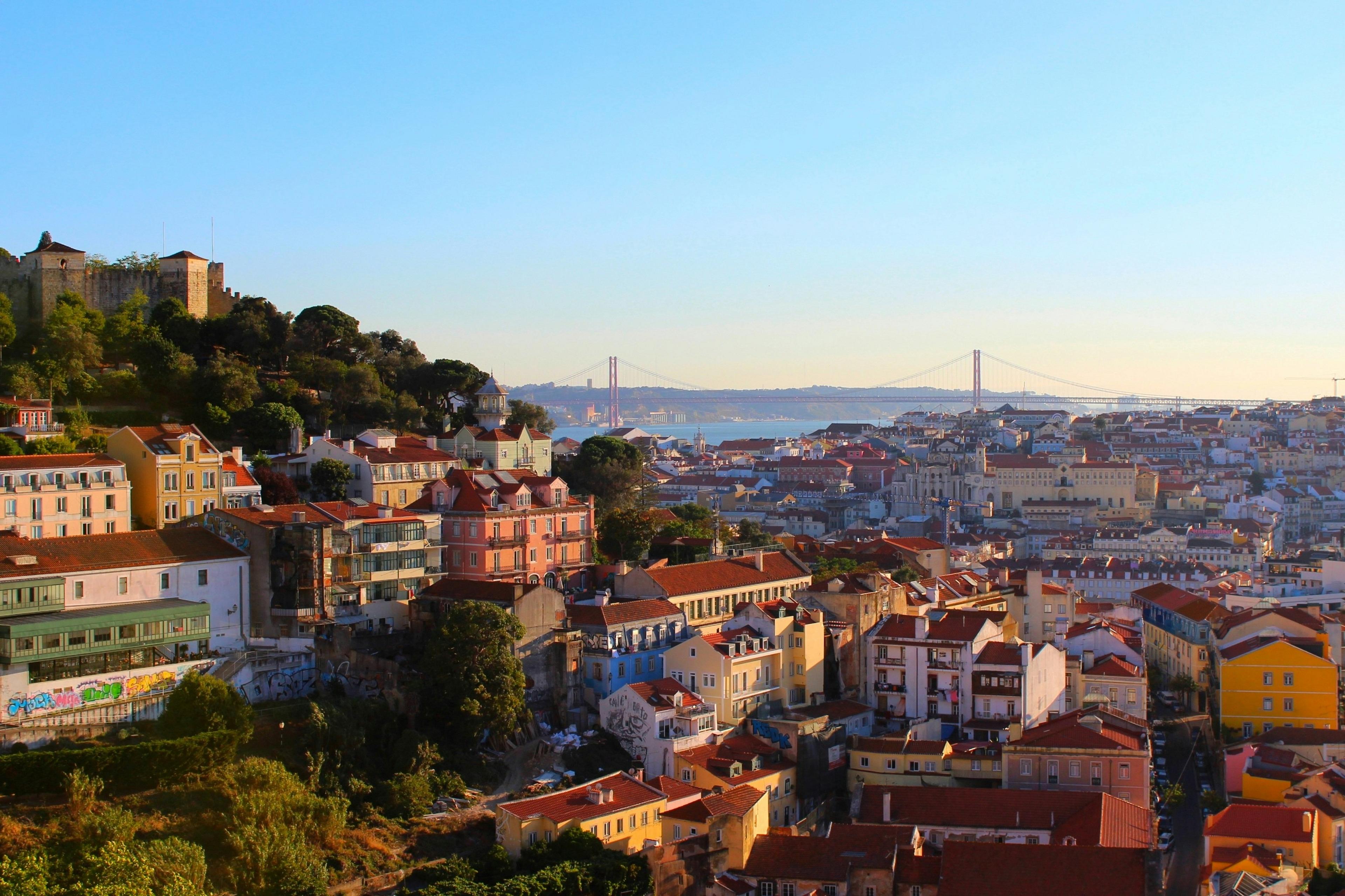 A vibrant view of Lisbon, Portugal, with the iconic 25 de Abril Bridge in the background.