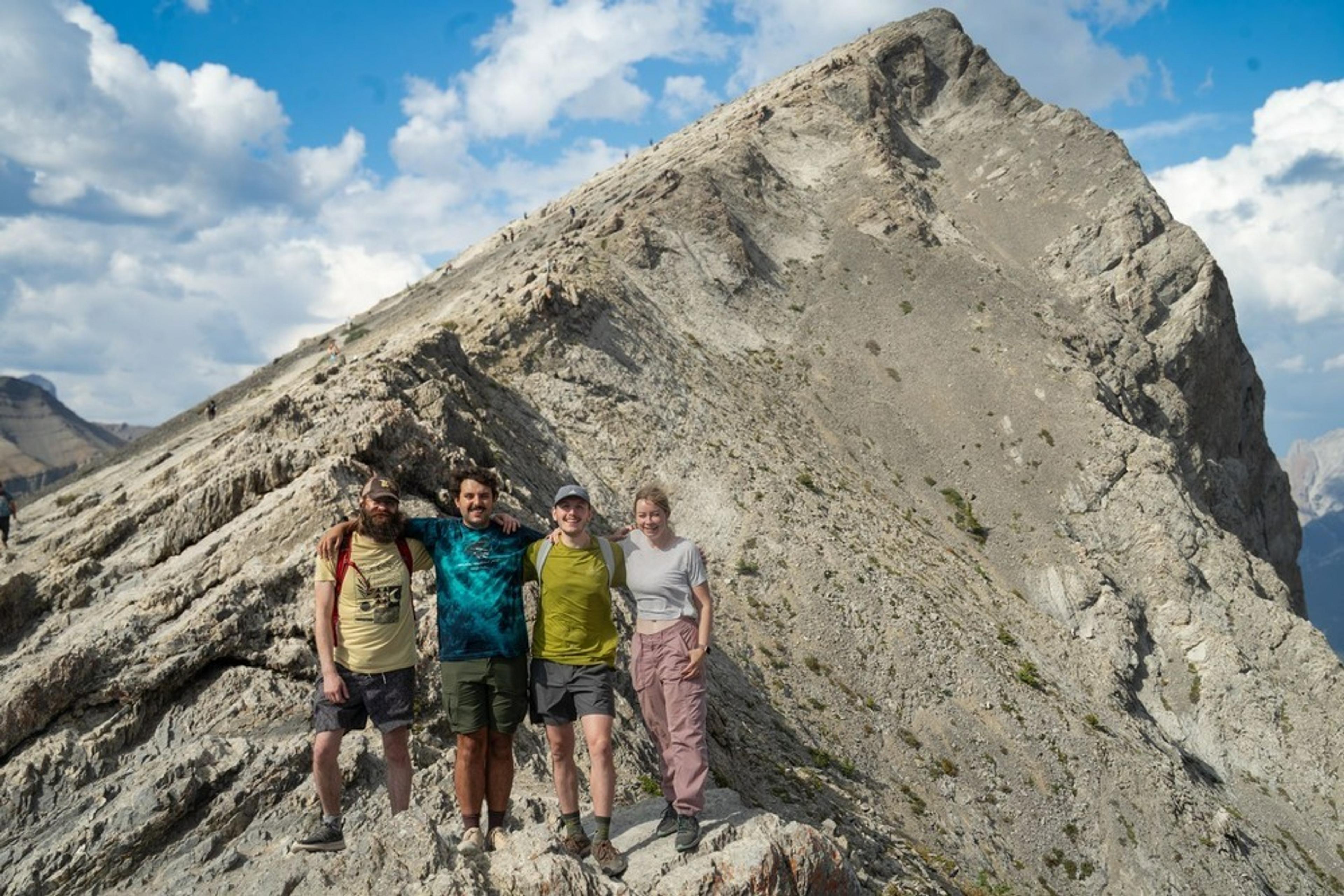 A group of hikers stands on the rocky slopes