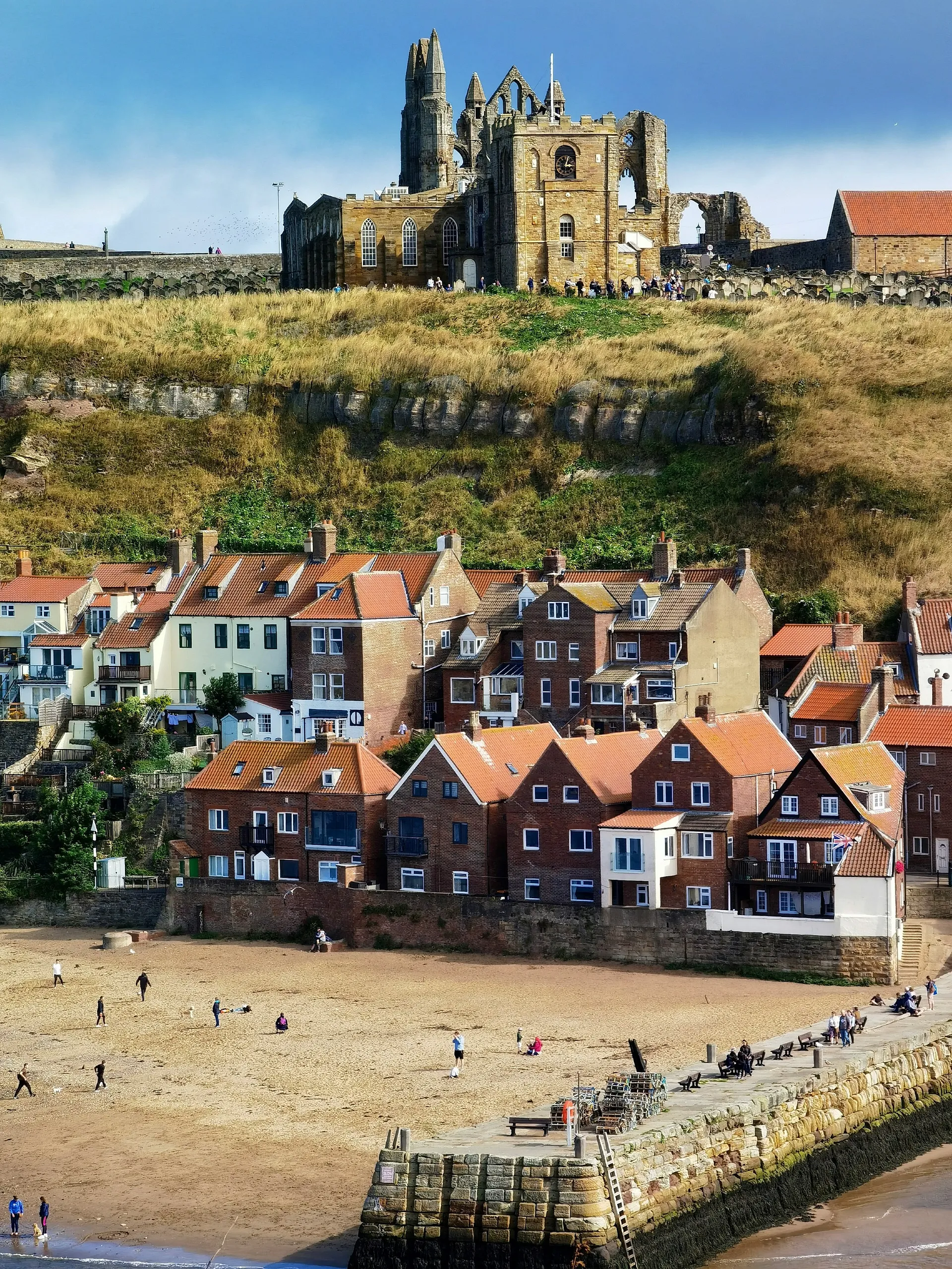 Whitby Abbey overlooking the sandy beach and quaint houses of Whitby, North Yorkshire.