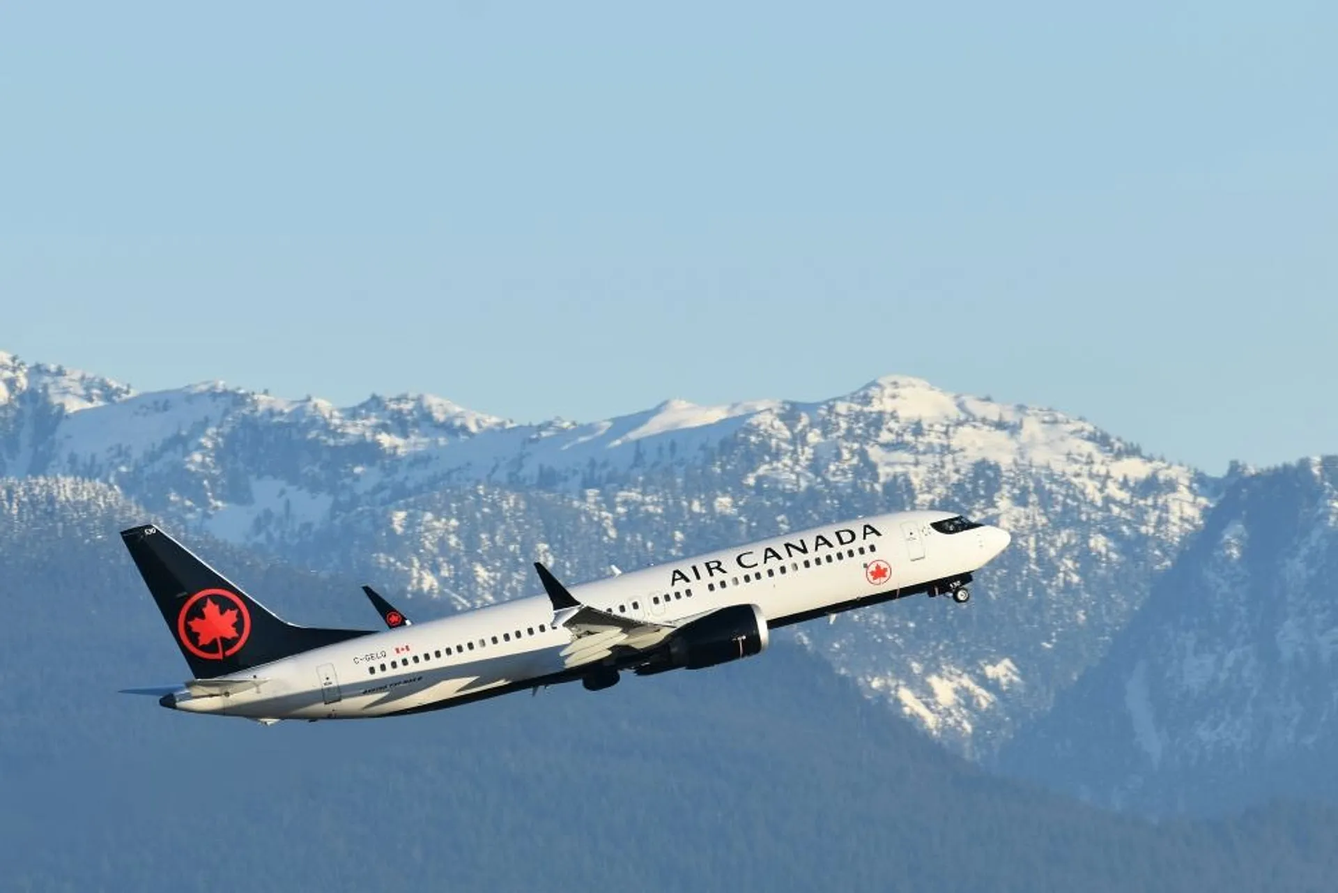 Air Canada plane taking off in front of mountains