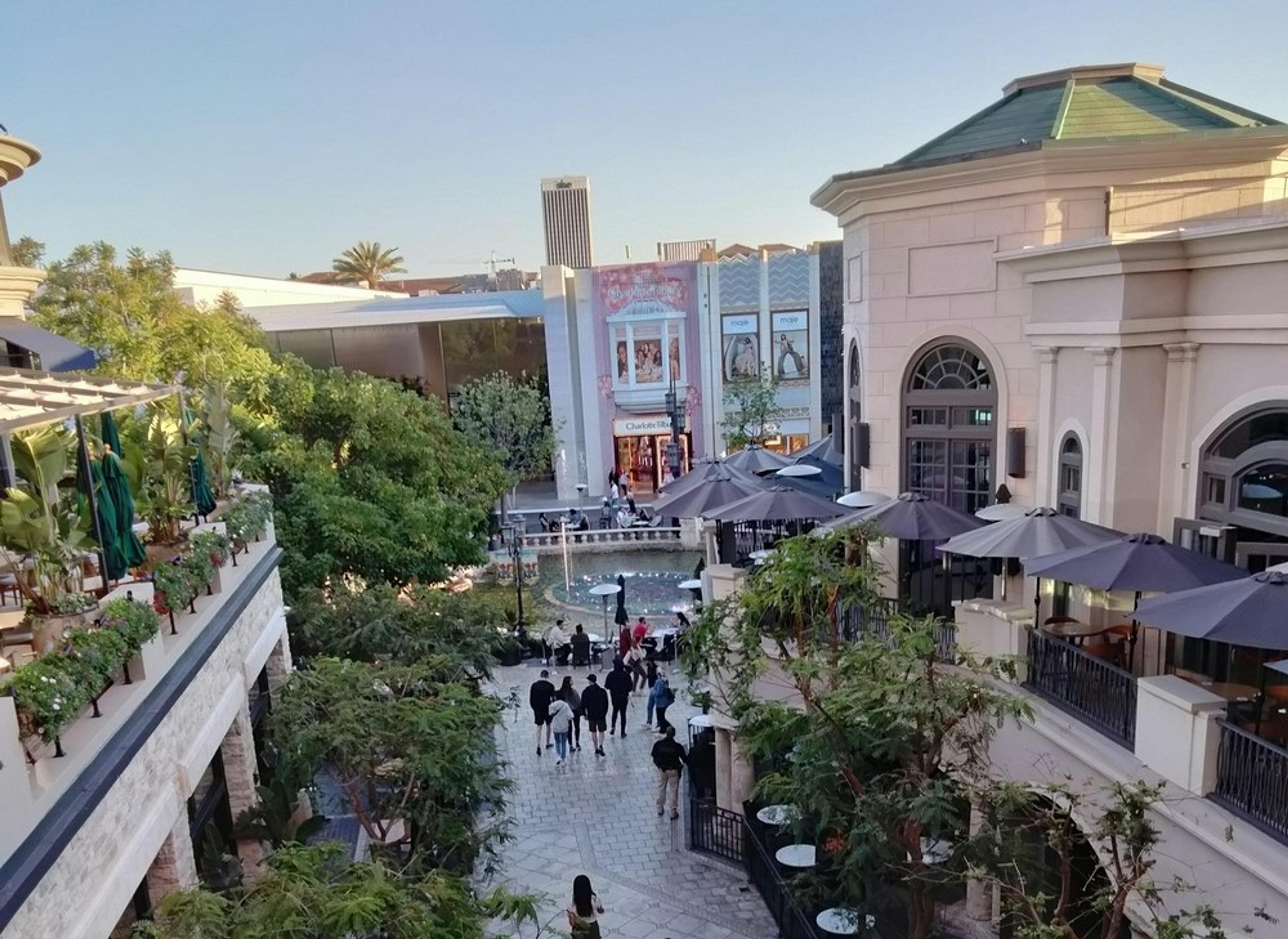 An upscale outdoor shopping area with restaurants and a small crowd, located at The Grove in Los Angeles.