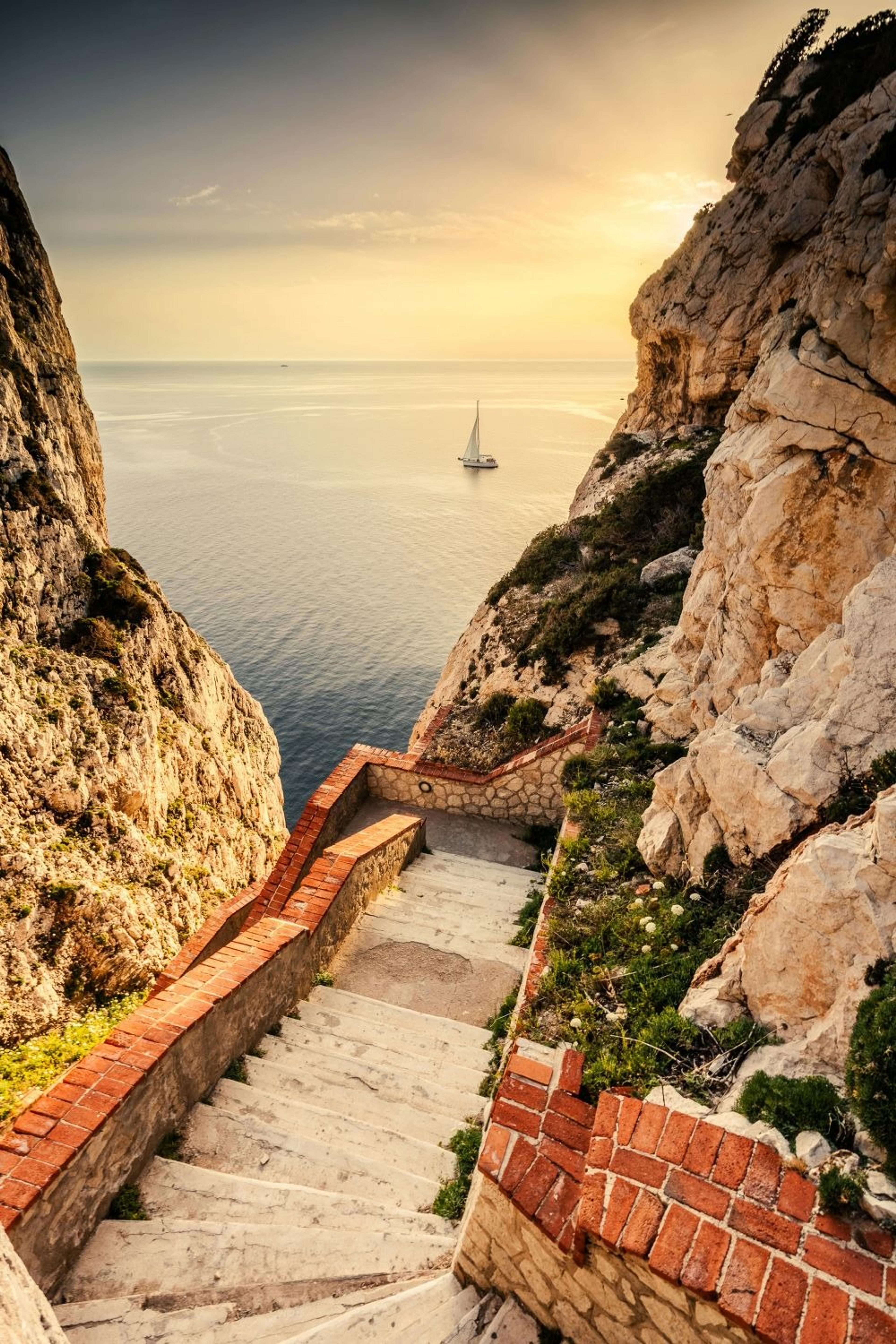 View of a sailboat between rocky cliffs