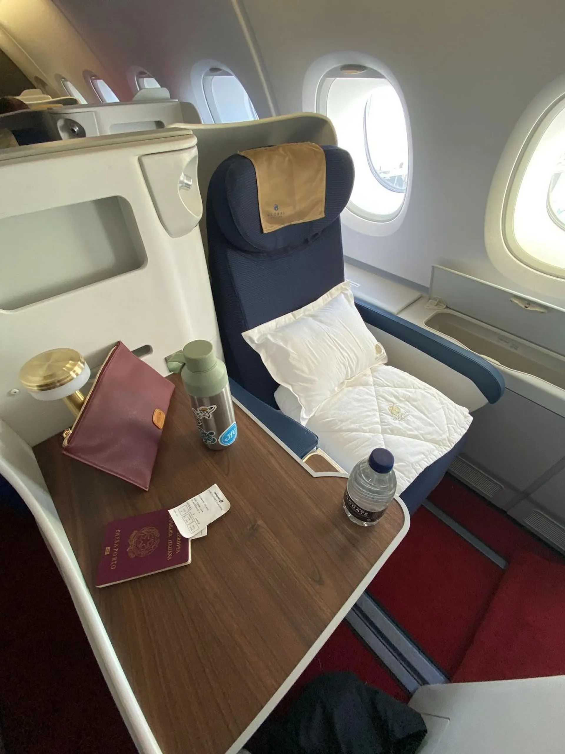 Single navy blue business class seat with side table