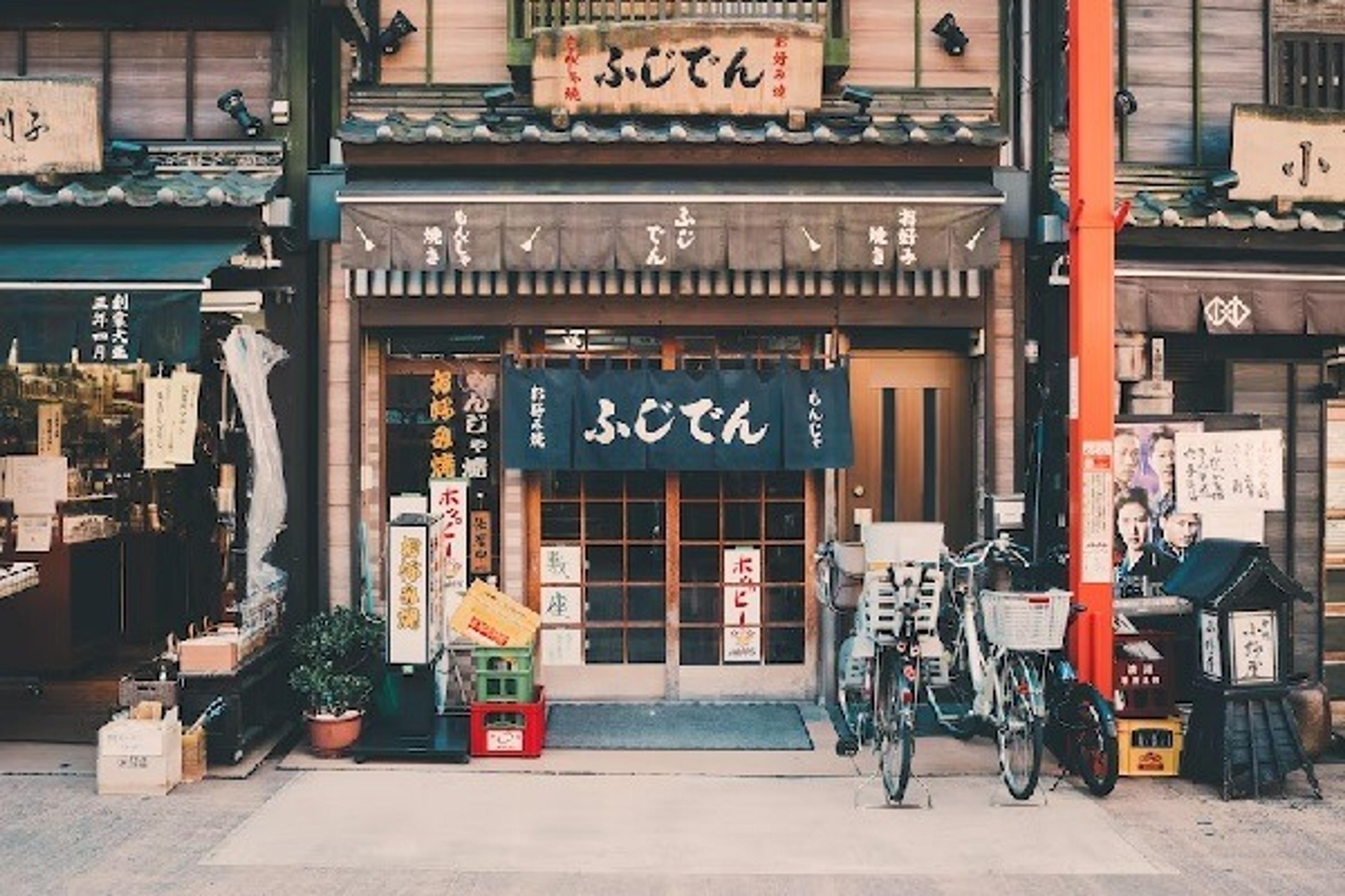 A shopfront featuring Japanese signs and three bicycles parked out front