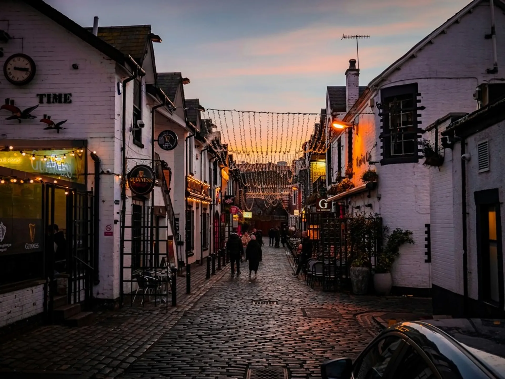 Sunset over white buildings and fairy lights on Ashton Lane, Glasgow