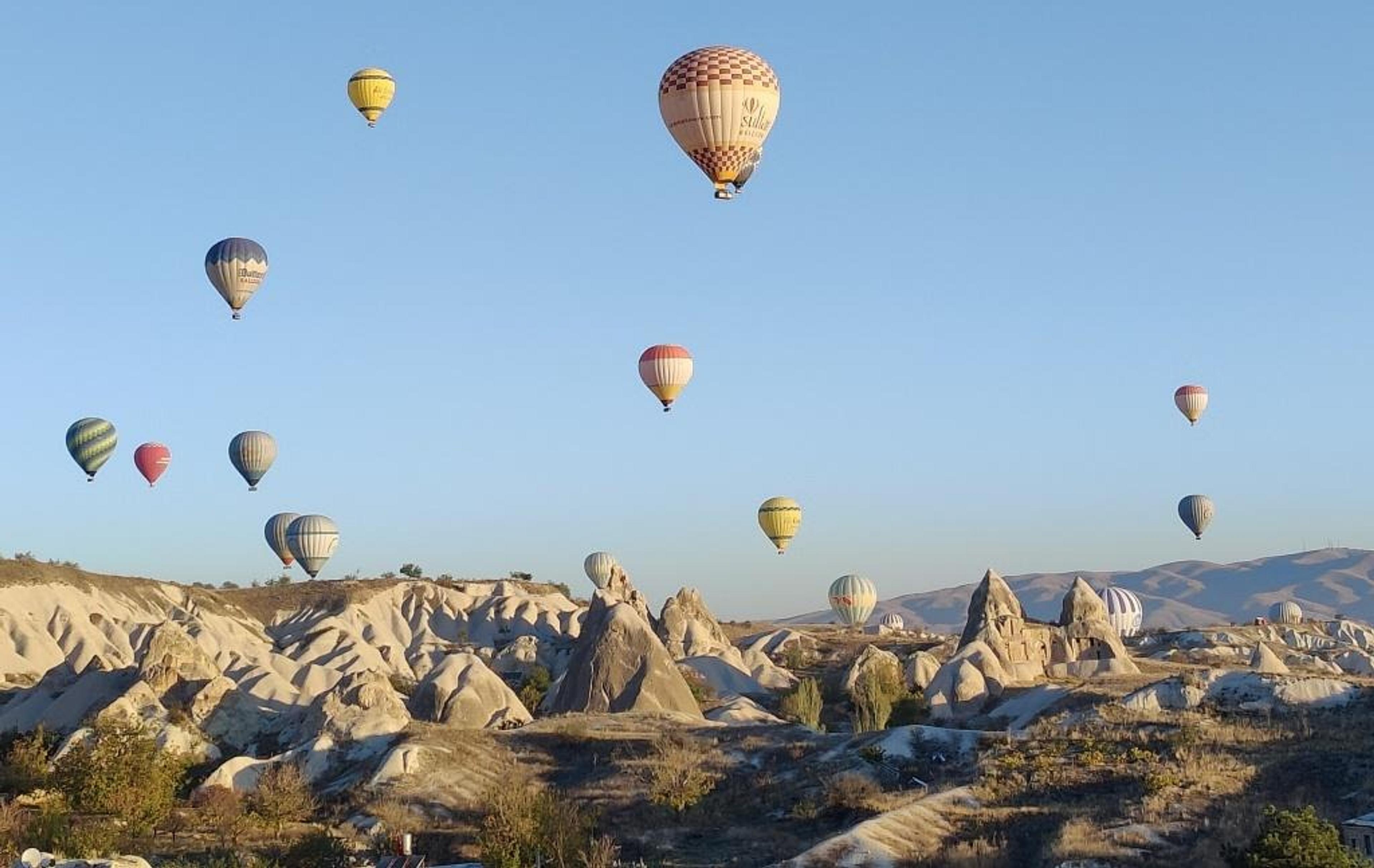 Hot air balloons rising over rock formations in Cappadocia