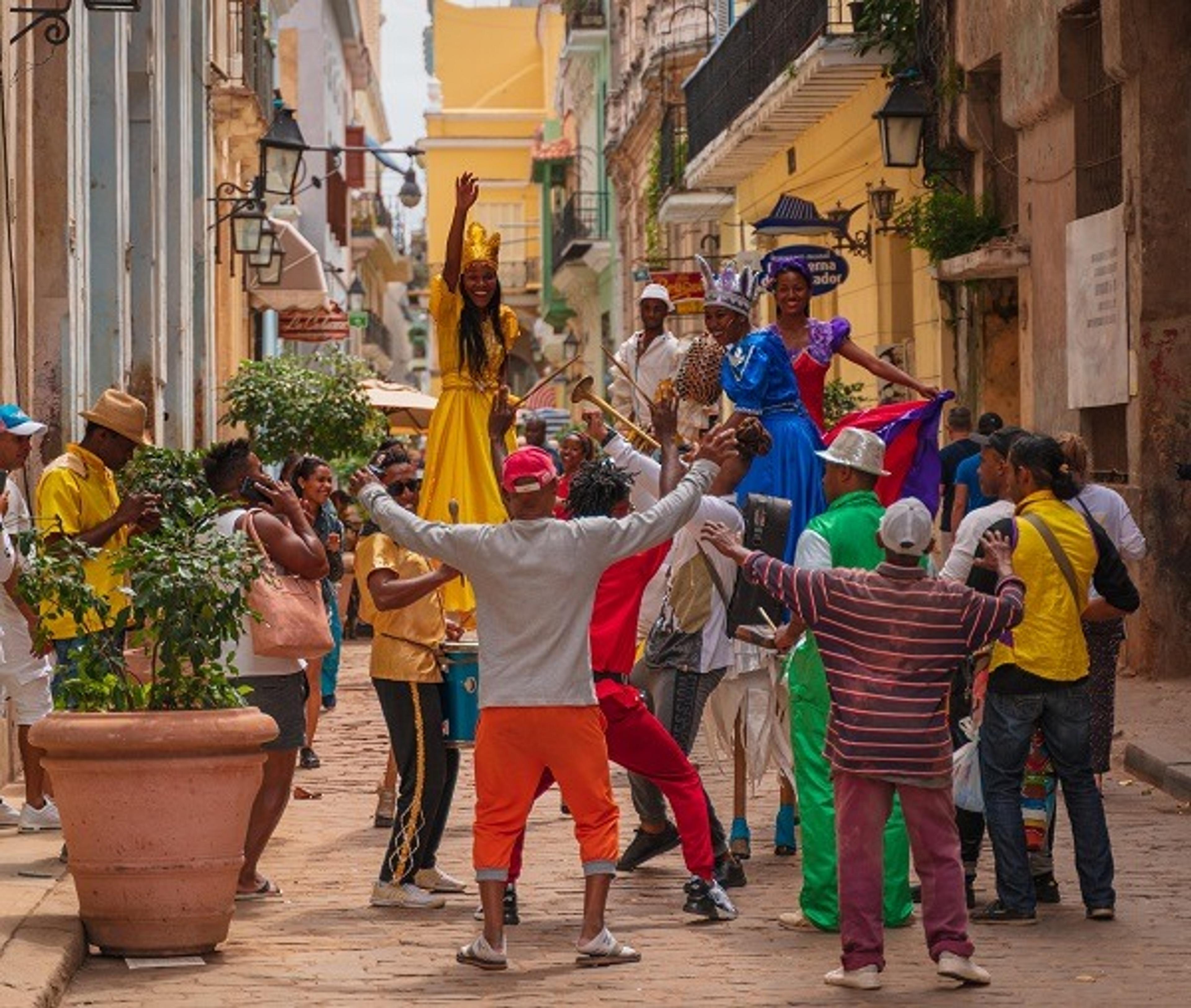 People wearing colorful clothing and dancing in the street in Havana, Cuba