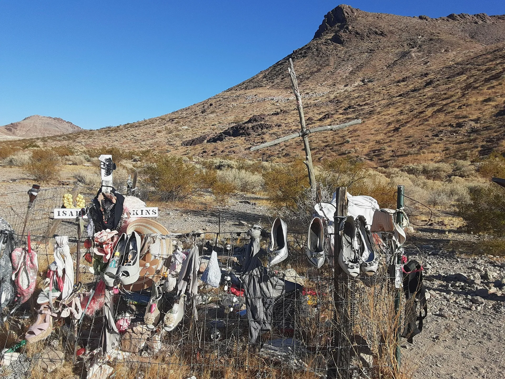 A memorial site adorned with shoes and mementos located in the desert near Rhyolite, Nevada.