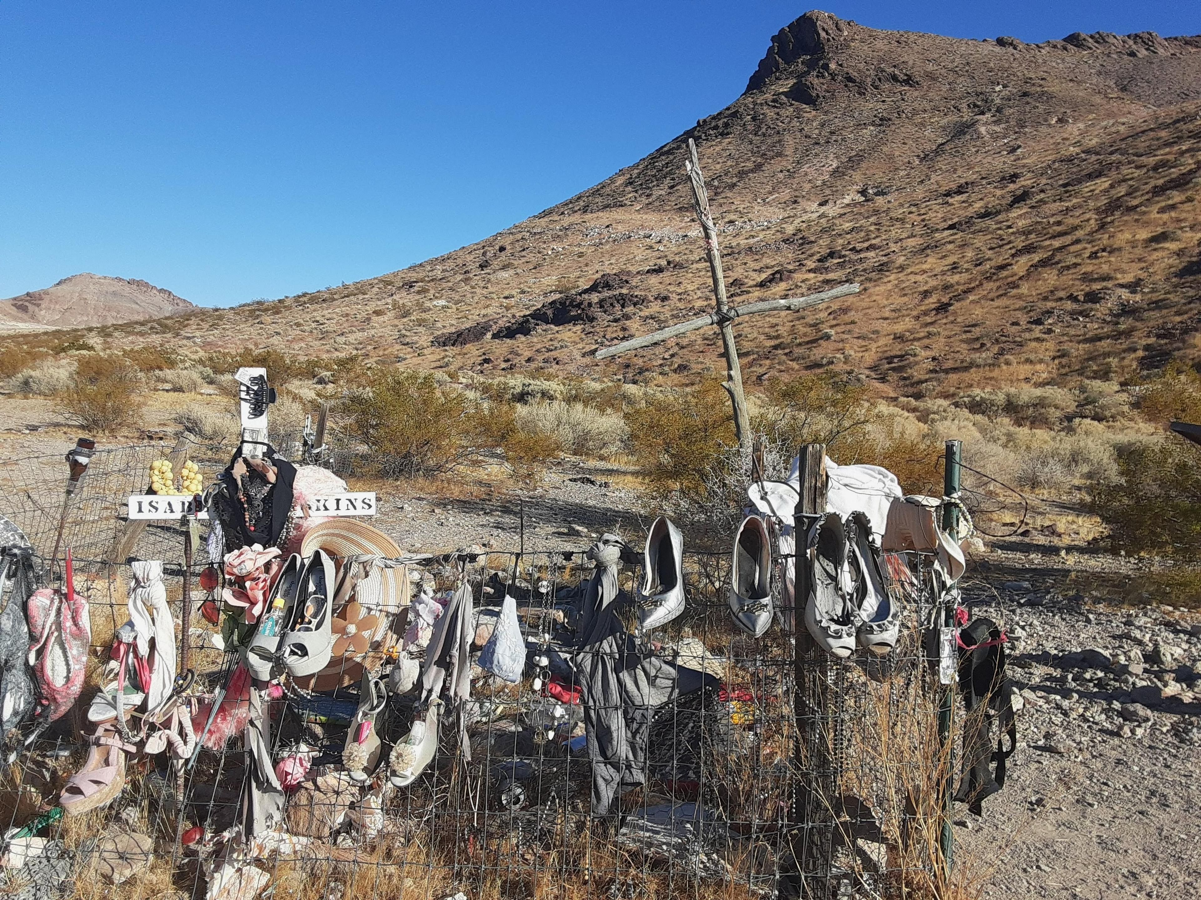 A memorial site adorned with shoes and mementos located in the desert near Rhyolite, Nevada.