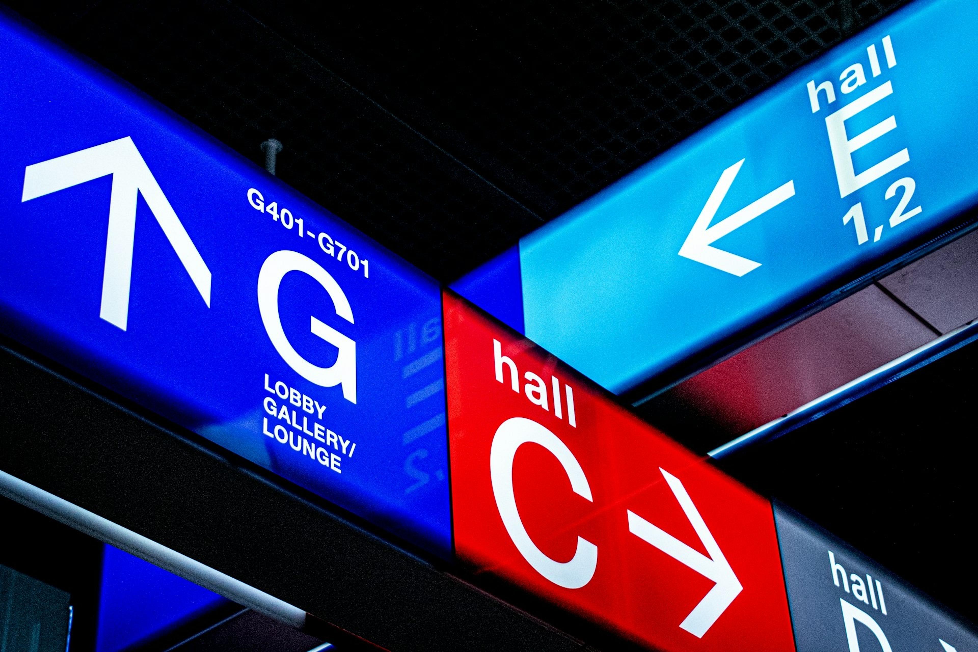 Colorful directional signs guide travelers through the terminals at Frankfurt Airport in Germany.