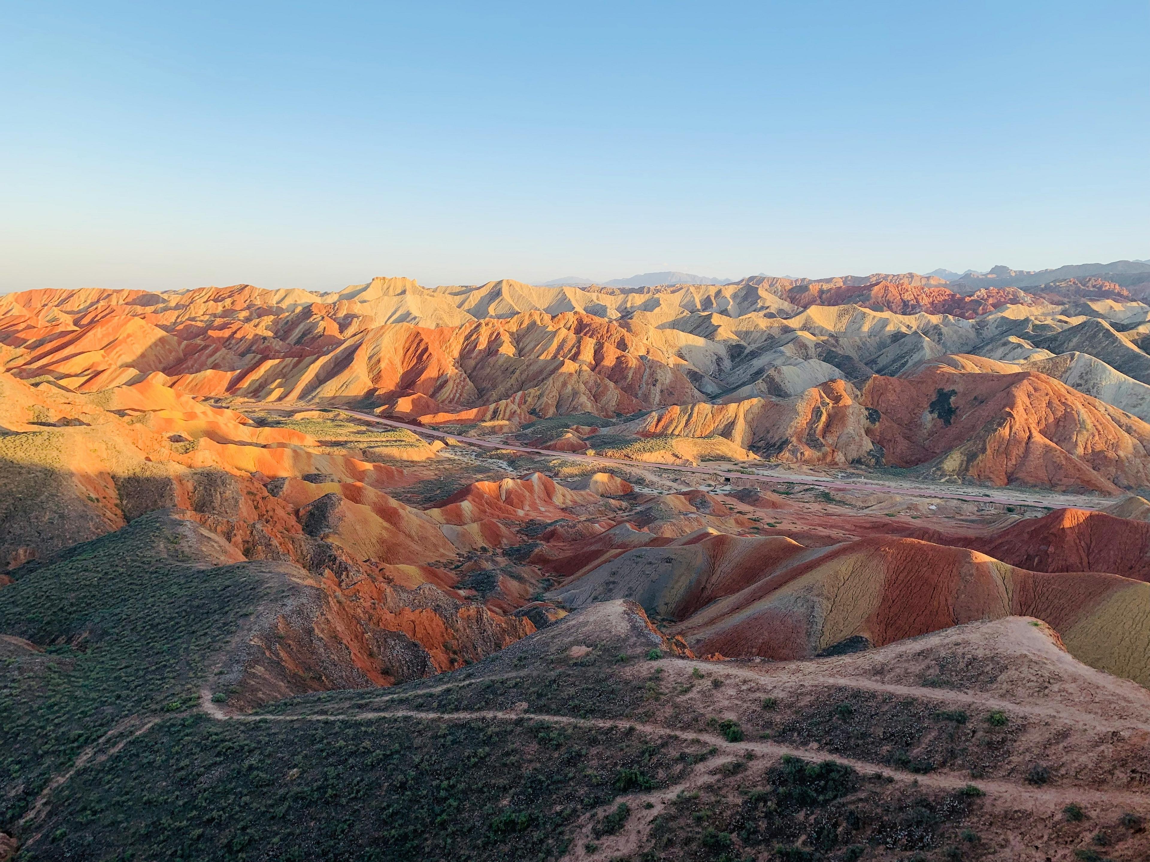 Colorful, layered rock formations stretch across the landscape in Zhangye Danxia National Geological Park, China.