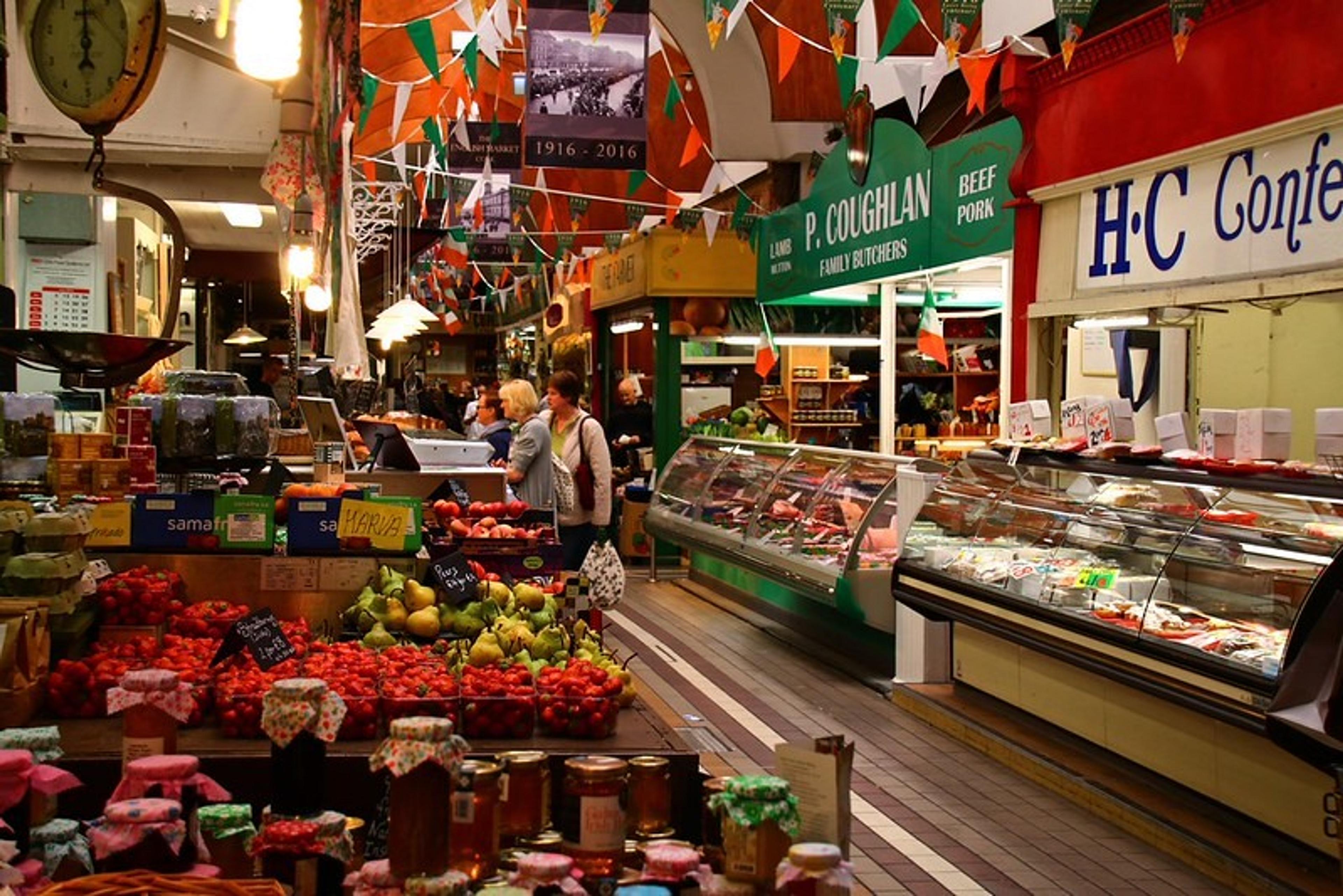 Shoppers explore the bustling stalls filled with fresh produce and meats inside the iconic English Market in Cork, Ireland.