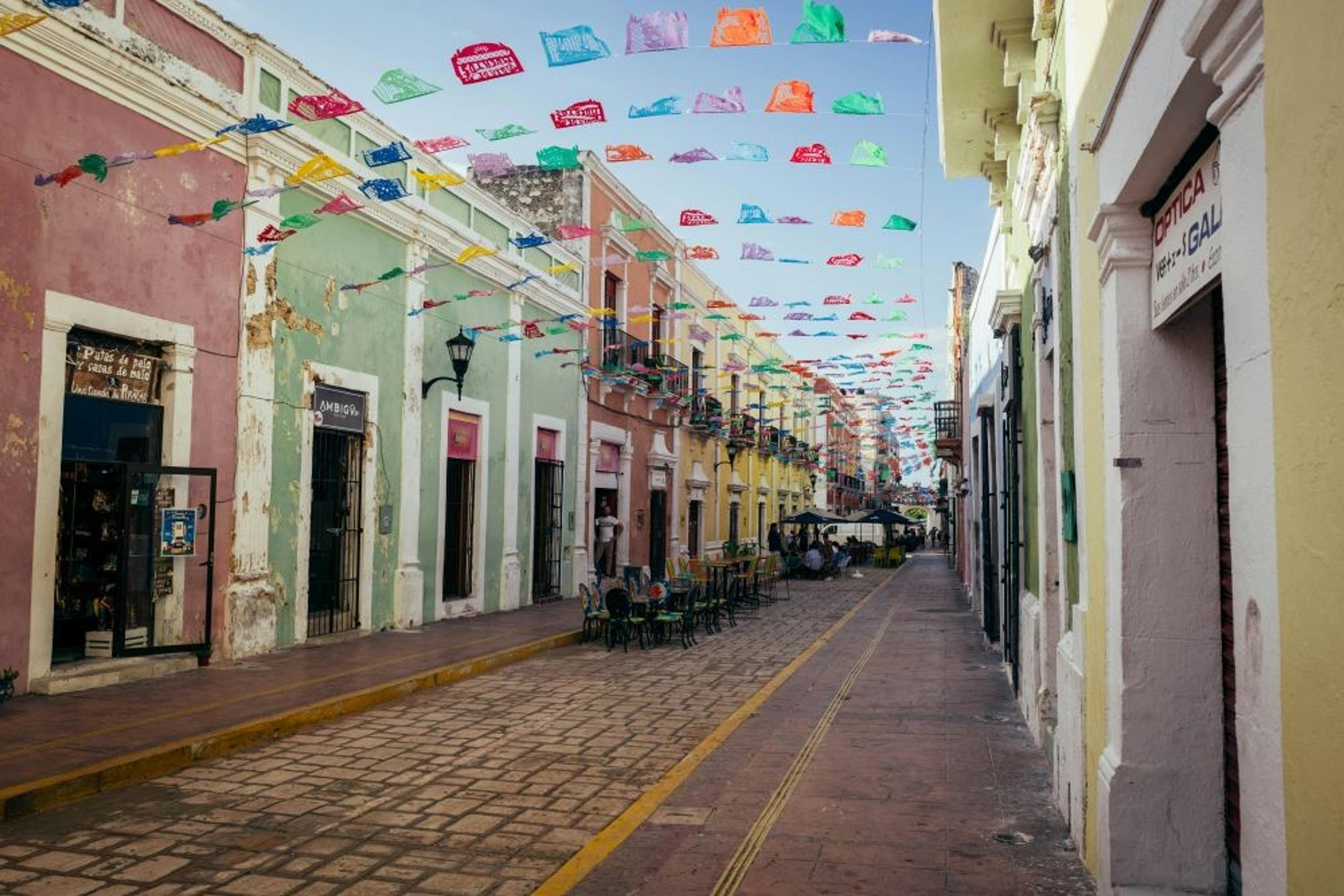 Colorful papel picado decorates a charming street in the historic center of Campeche, Mexico.