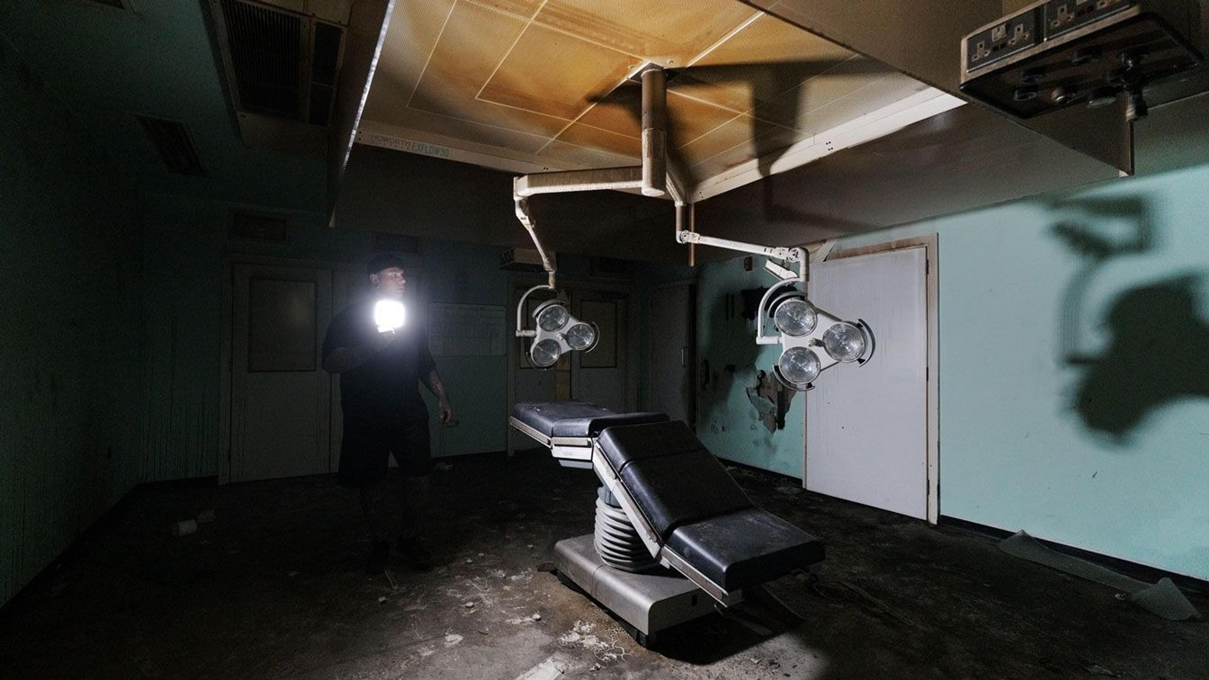 Simon, an urban explorer standing in a dimly lit abandoned morgue