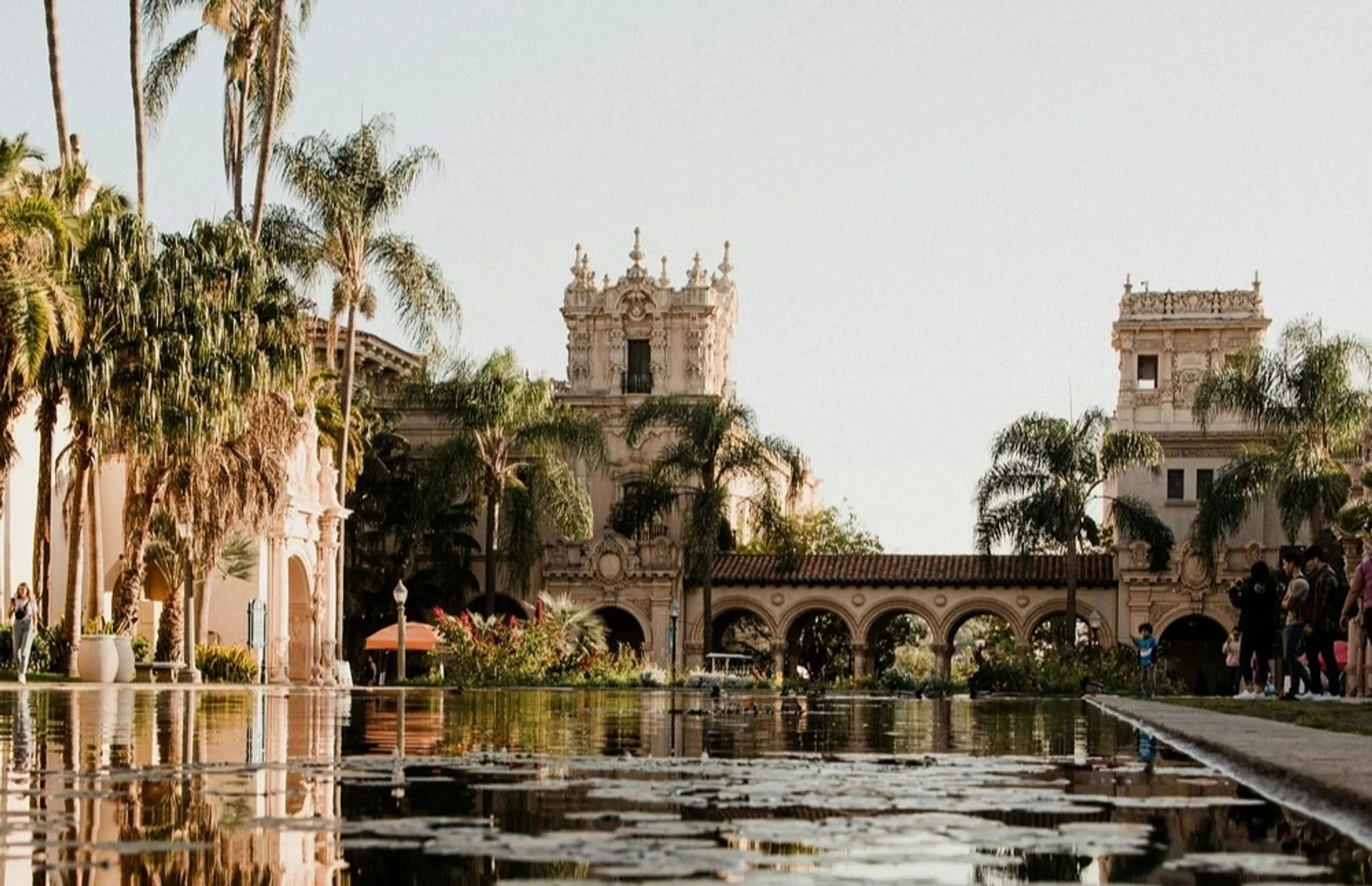 Balboa Park in San Diego features Spanish-style architecture and a serene reflecting pool lined with palm trees.