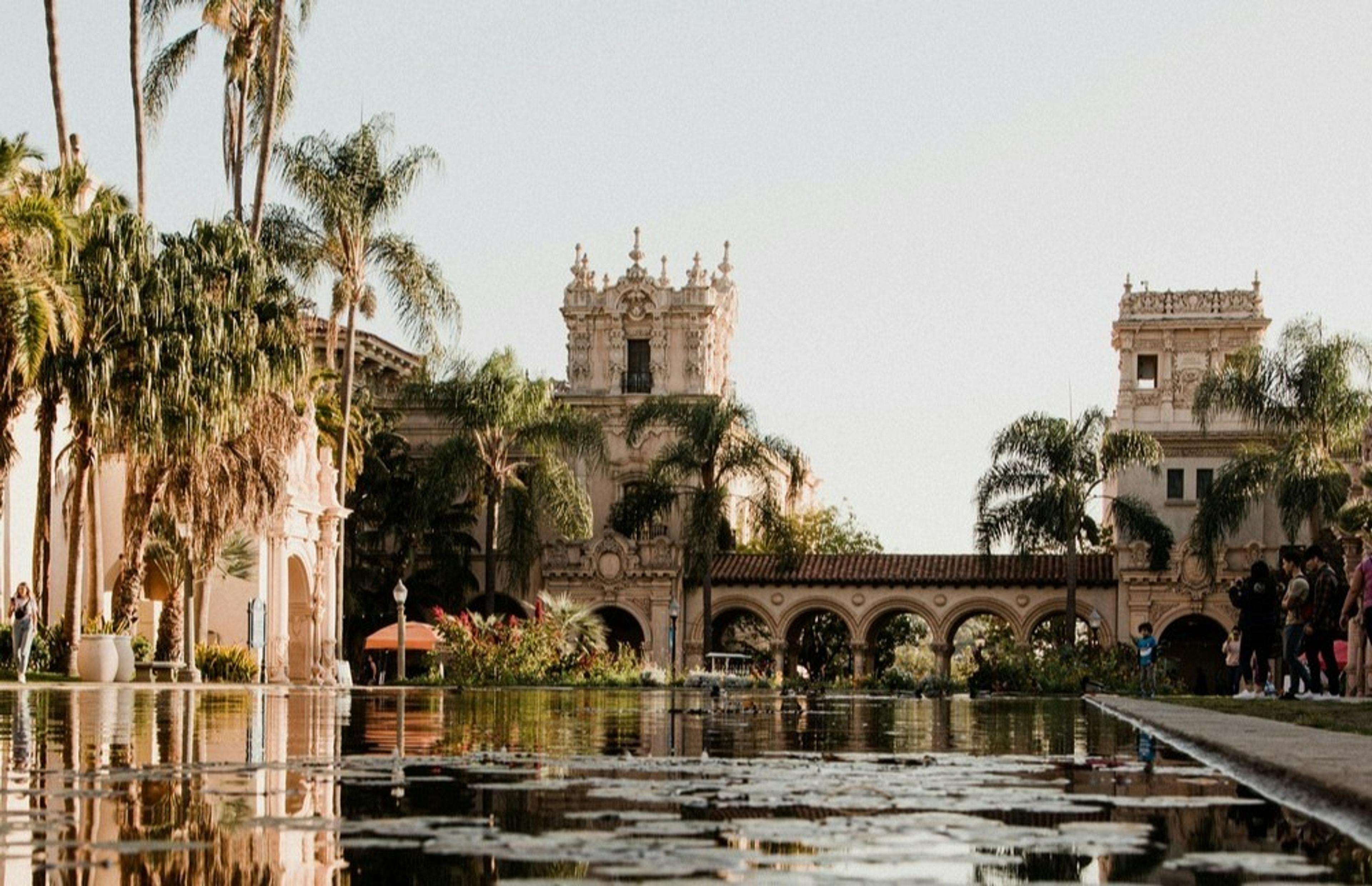 Balboa Park in San Diego features Spanish-style architecture and a serene reflecting pool lined with palm trees.