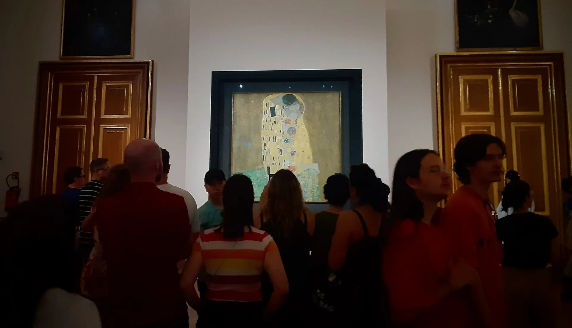 A crowd gathers around "The Kiss" by Gustav Klimt at the Österreichische Galerie Belvedere in Vienna.