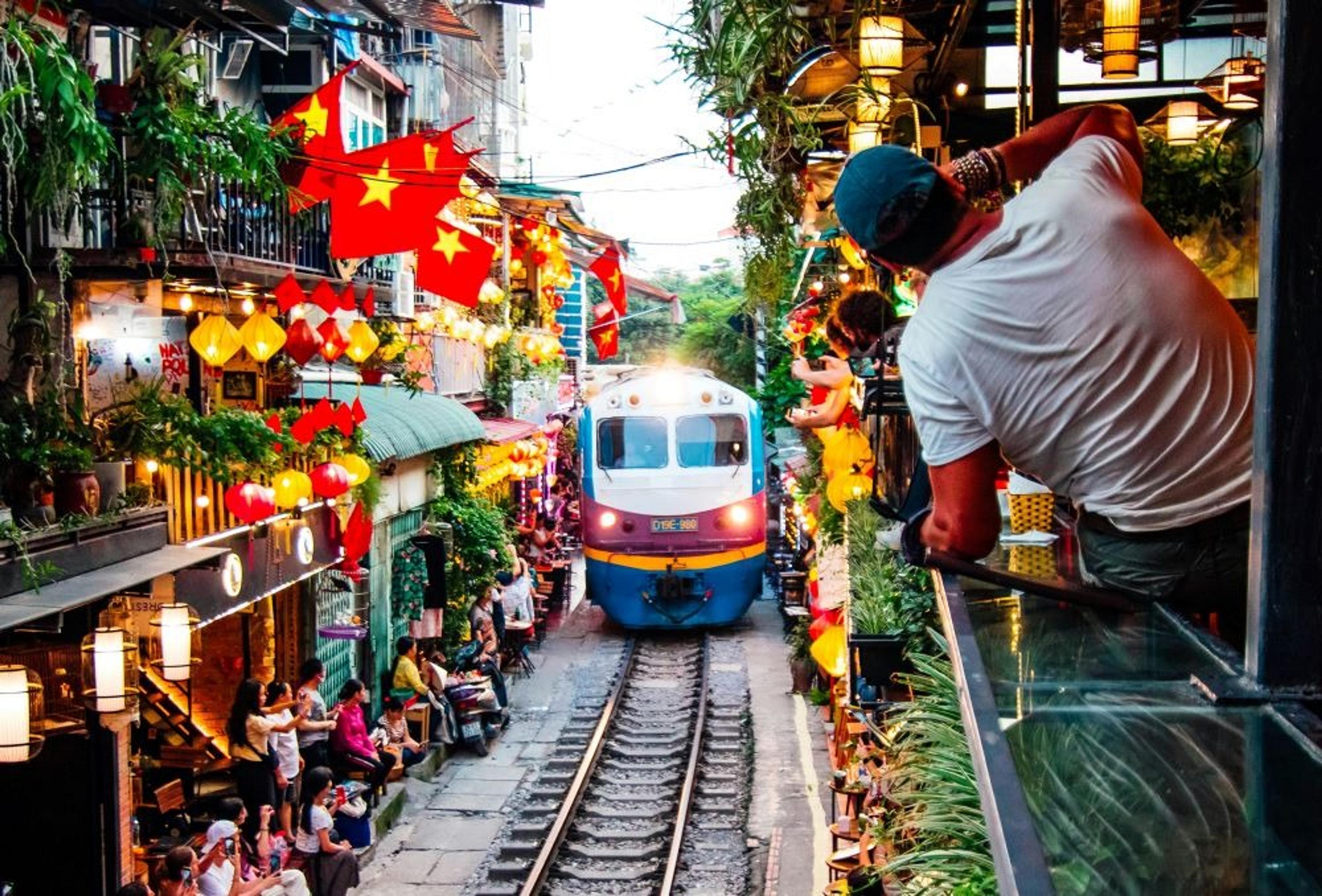 Train travelling along a narrow street in Vietnam