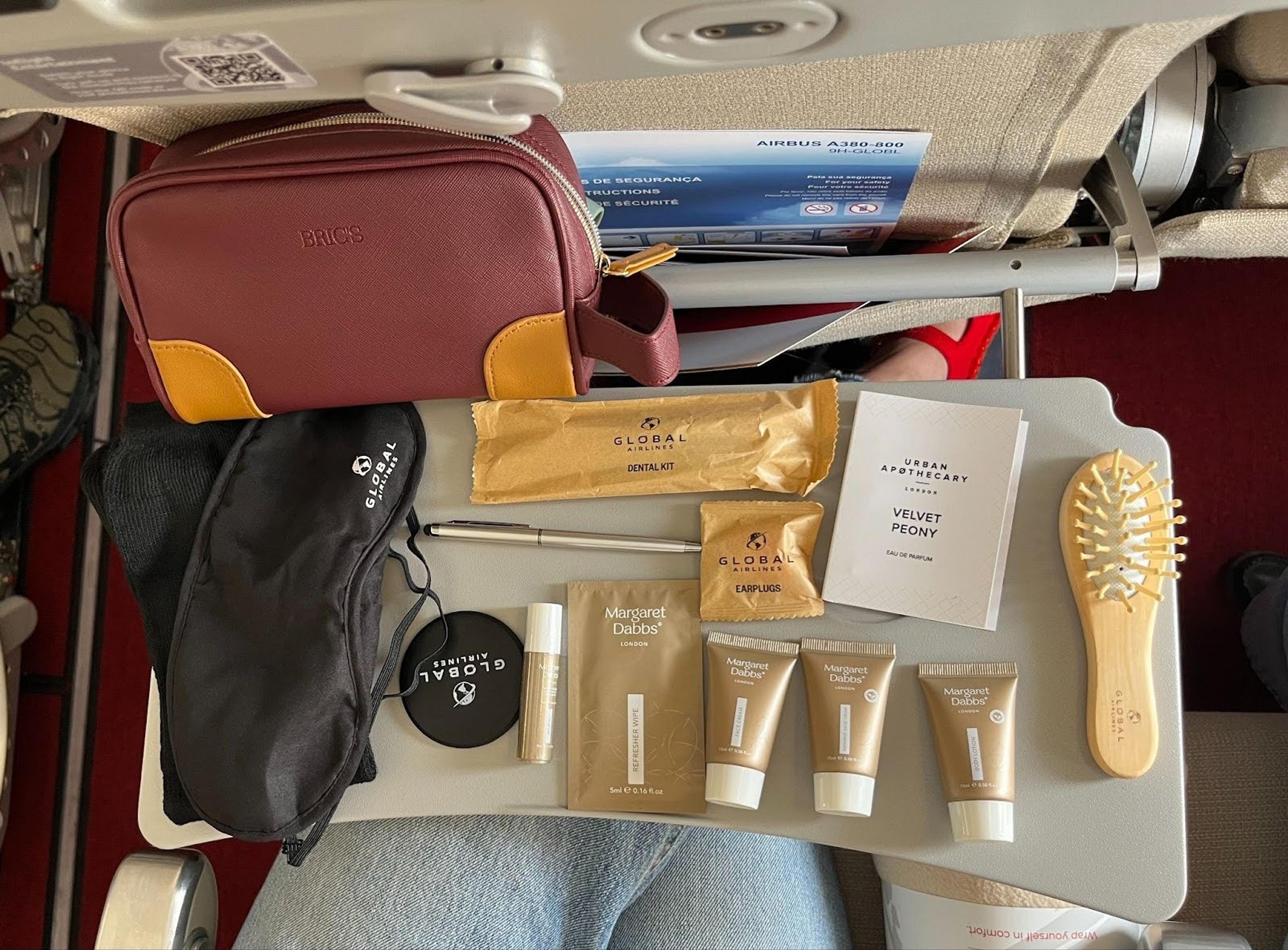 Red amenity kit bag with several items laid out on the table