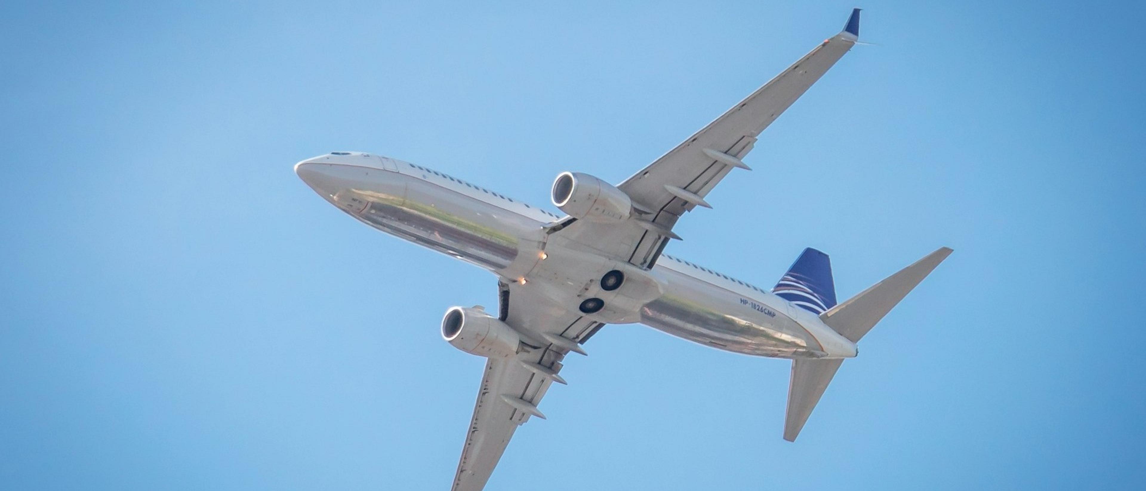 A commercial airplane in flight, captured against a clear blue sky.
