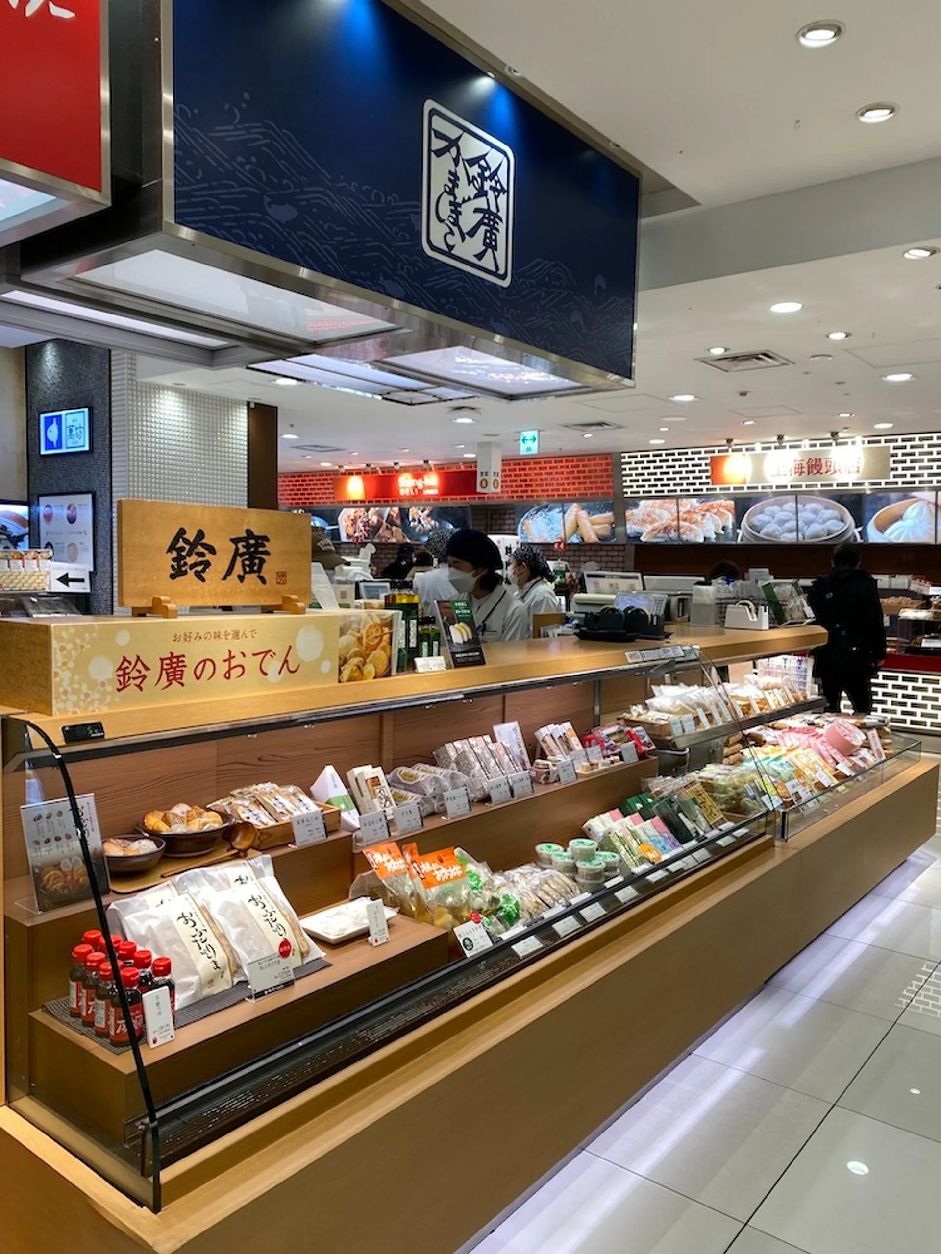 A bustling food stall features an array of packaged products and ready-to-eat meals.
