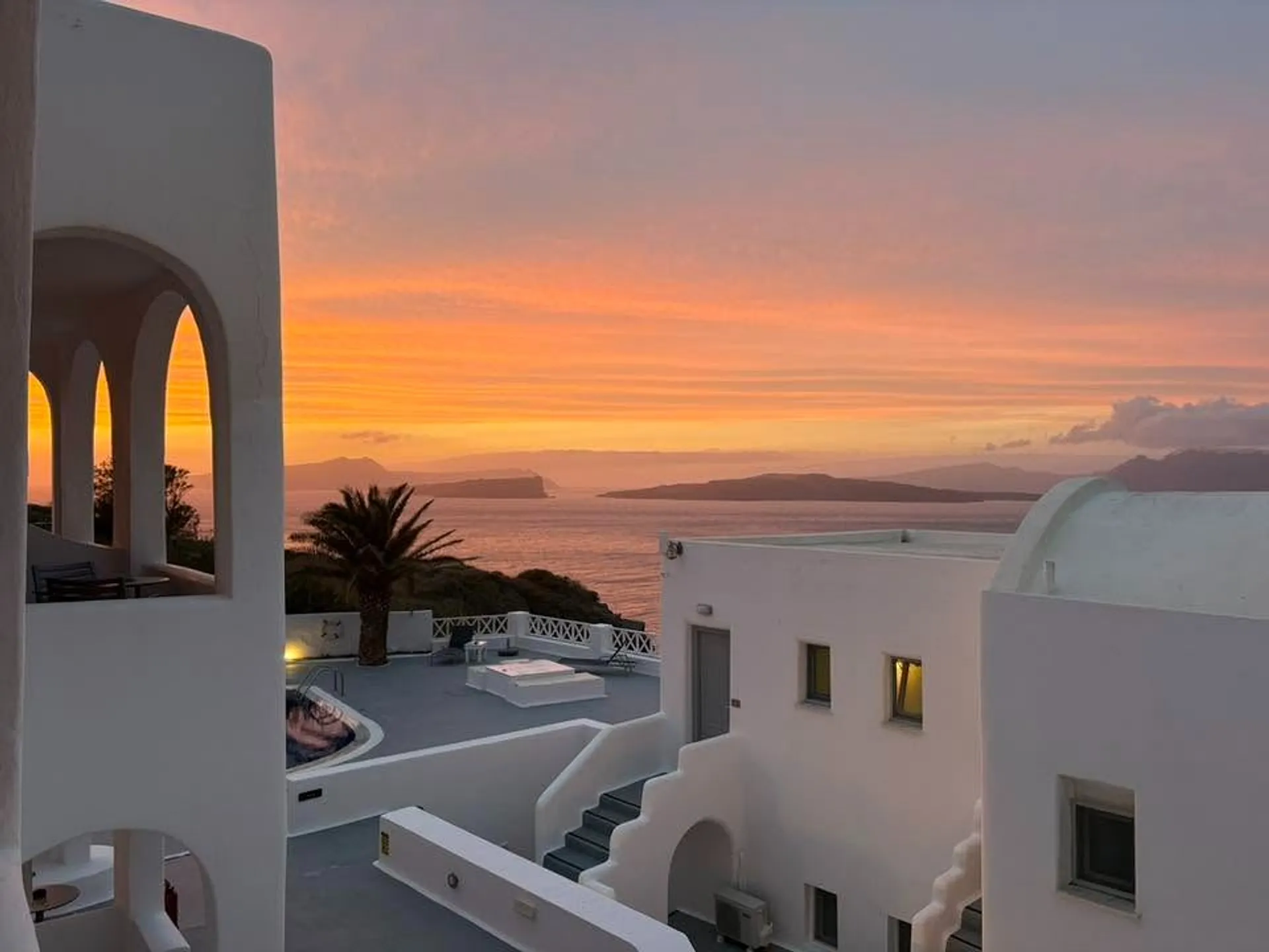 A stunning sunset view over white-washed buildings in Santorini, Greece.