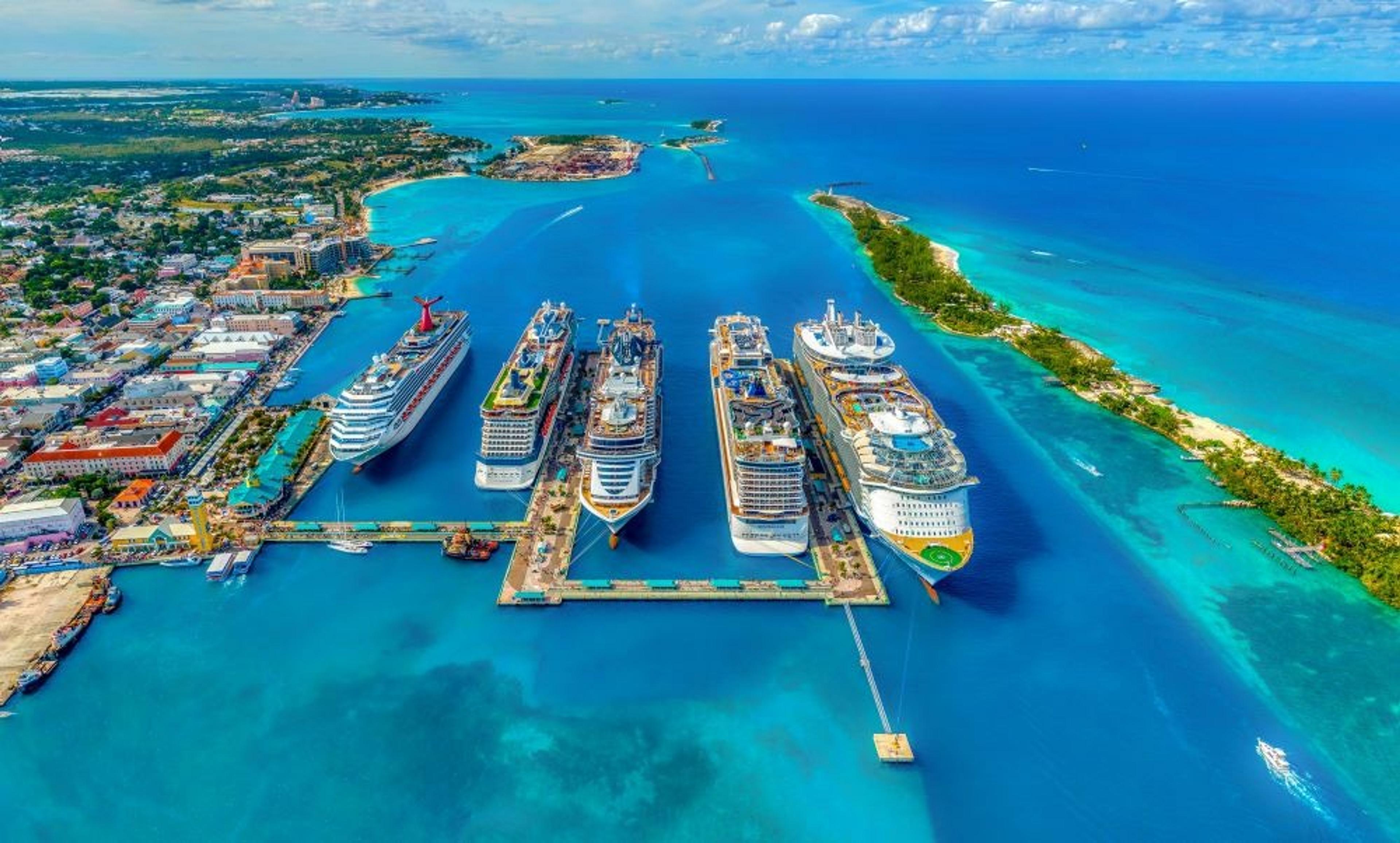 Five cruise ships docked in turquoise bahamian waters