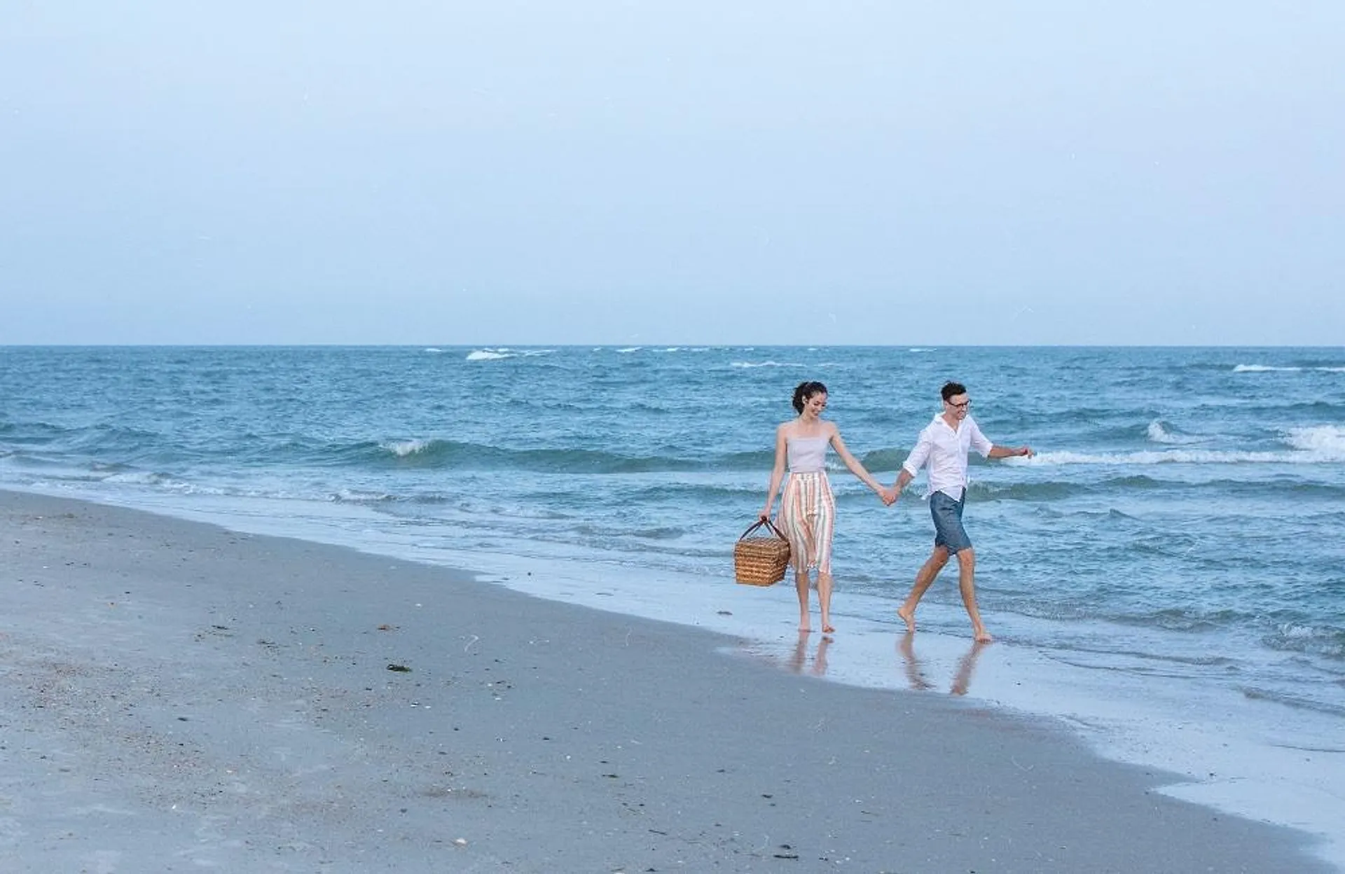 Two people holding hands on the beach