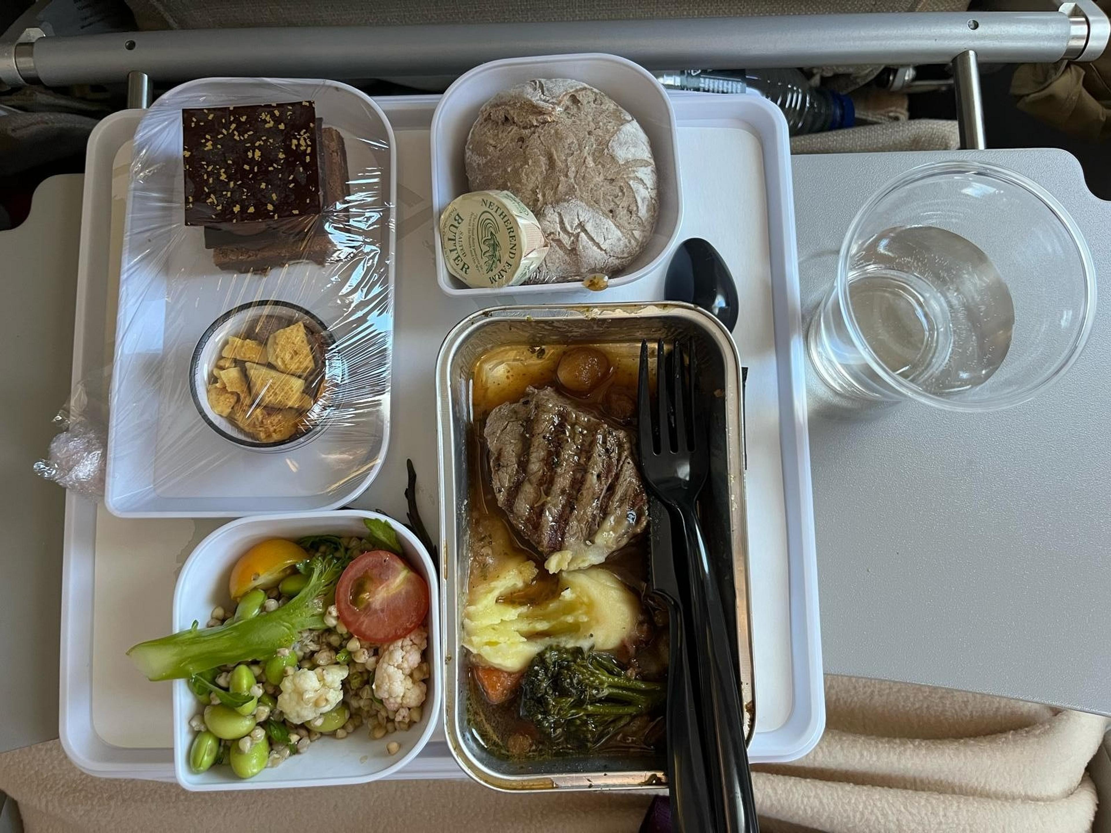 Steak dinner, vegetables, bread, chocolate dessert and a drink