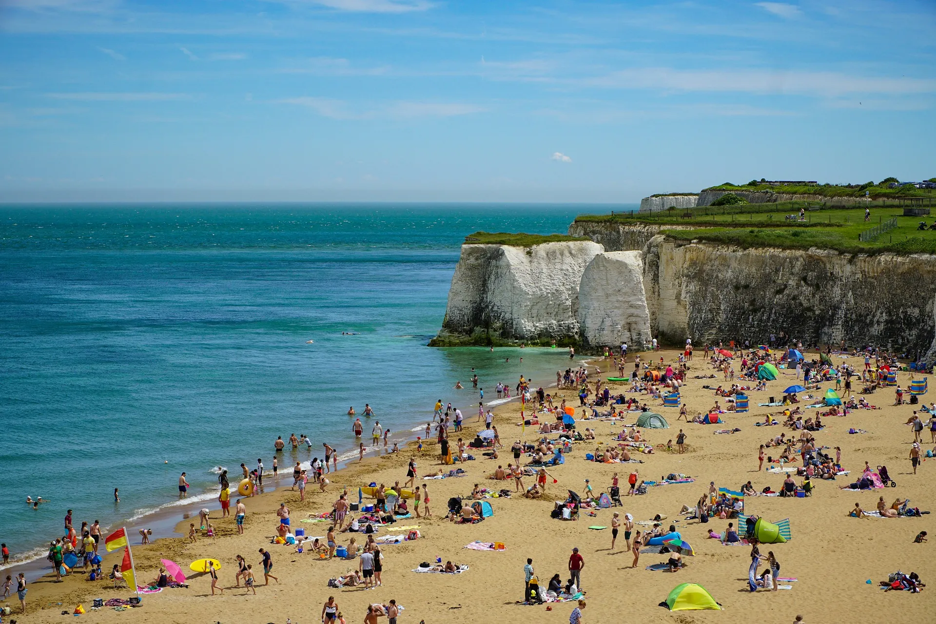 A bustling summer day at Margate with its iconic white chalk cliffs and sandy beach.