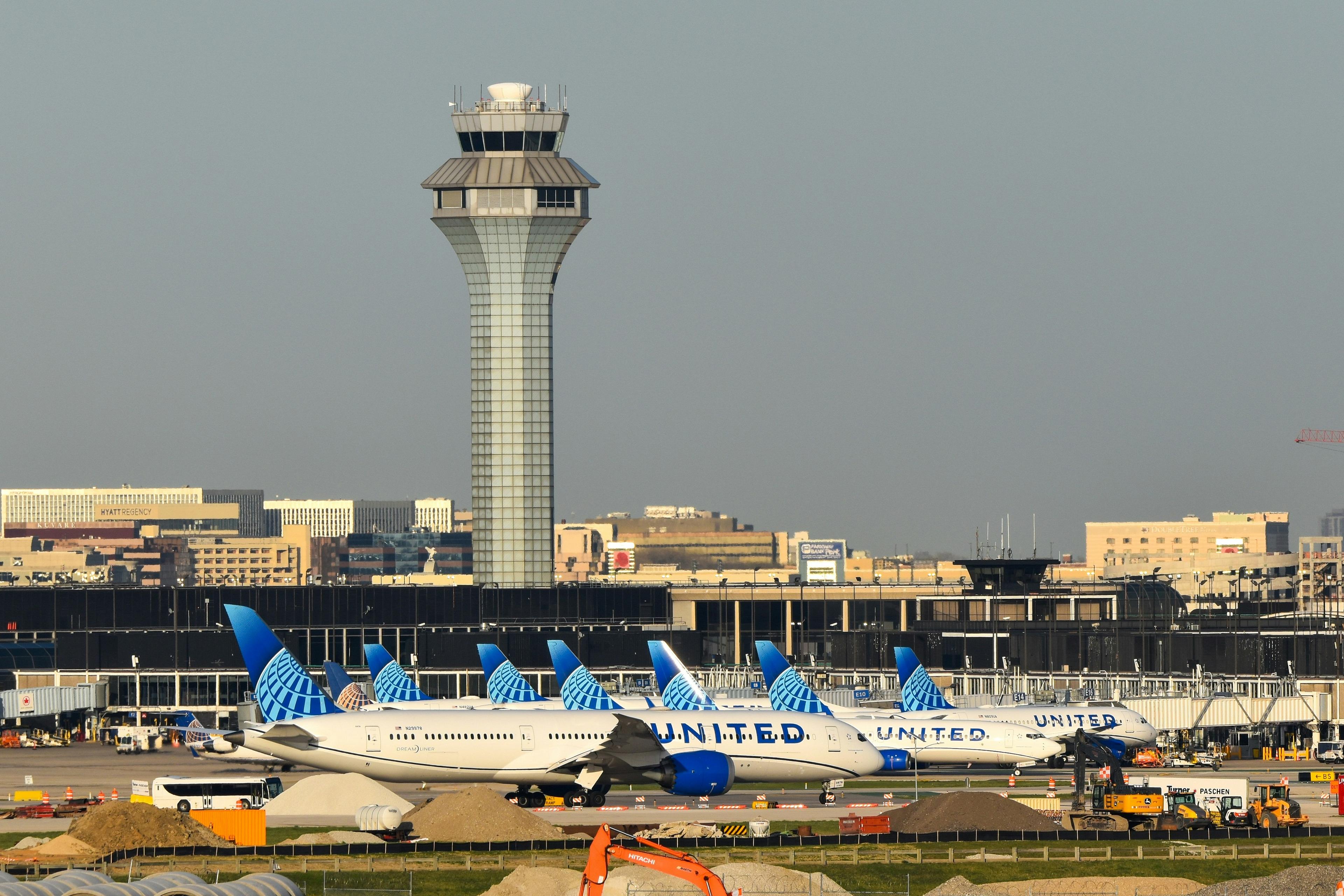 O'Hare International Airport in Chicago displays several United Airlines planes lined up near the control tower.
