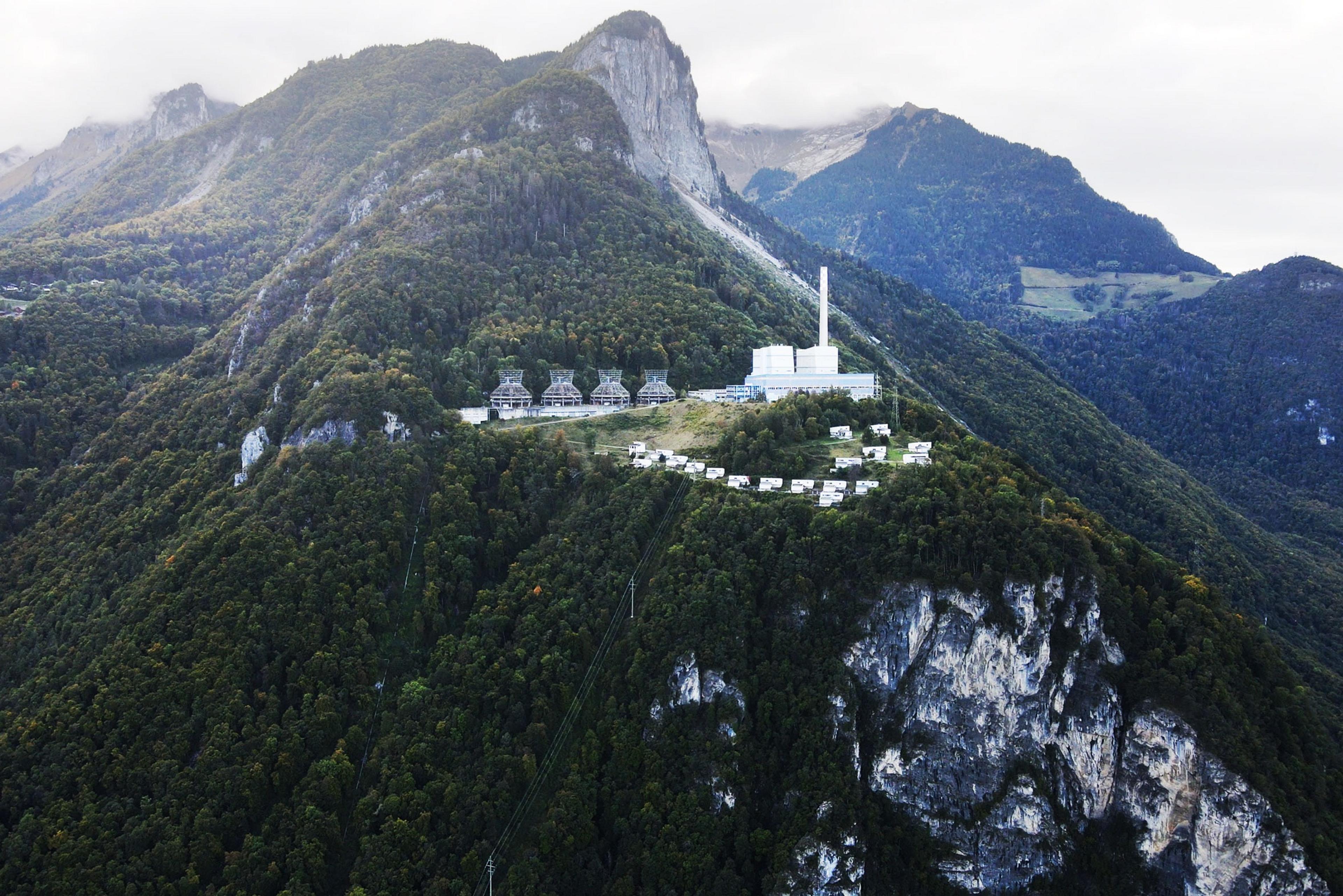 An abandoned Thermal Power Plant in Switzerland, stands against a misty mountain backdrop.