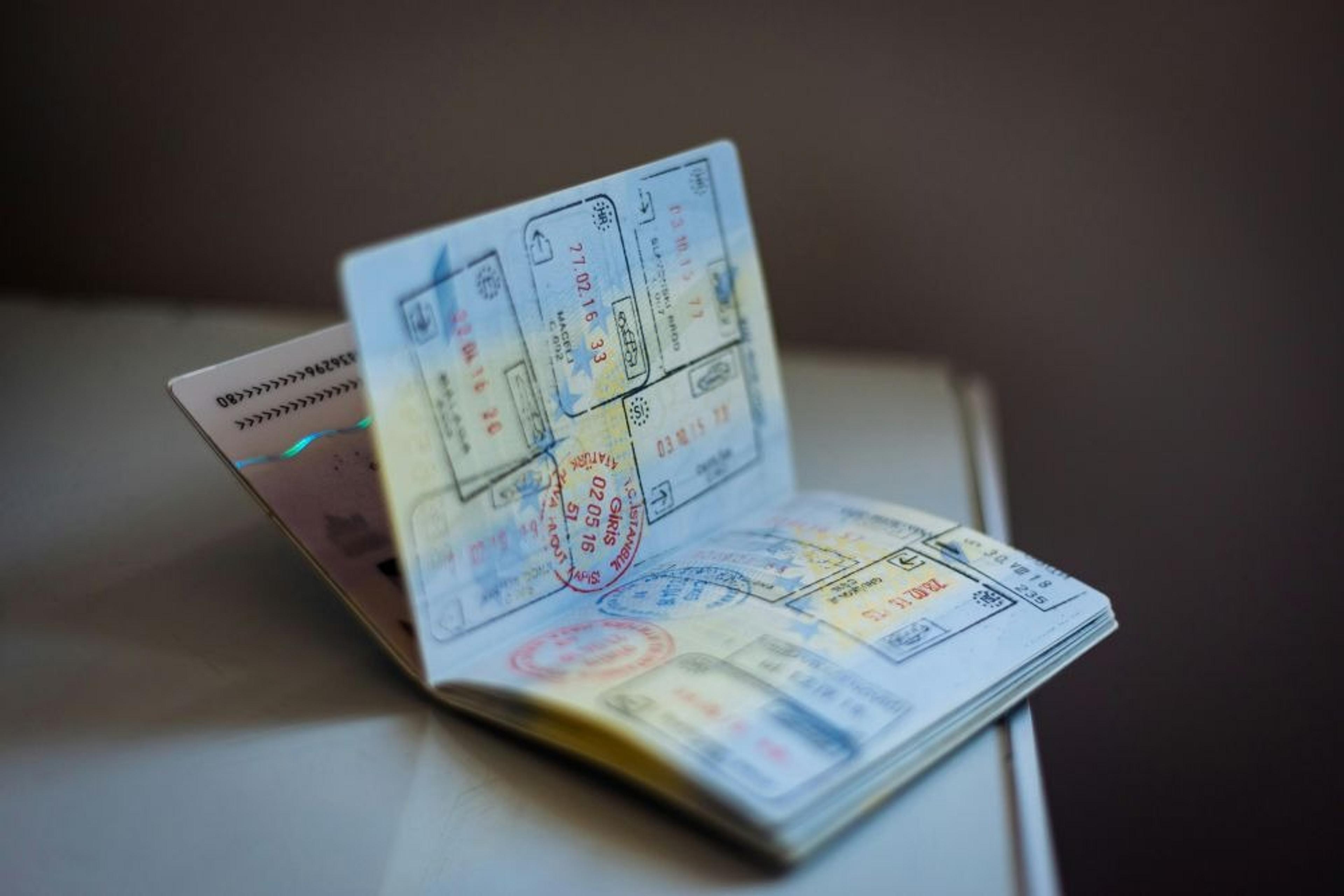 A well-stamped passport resting on a table reflects diverse global travel experiences.
