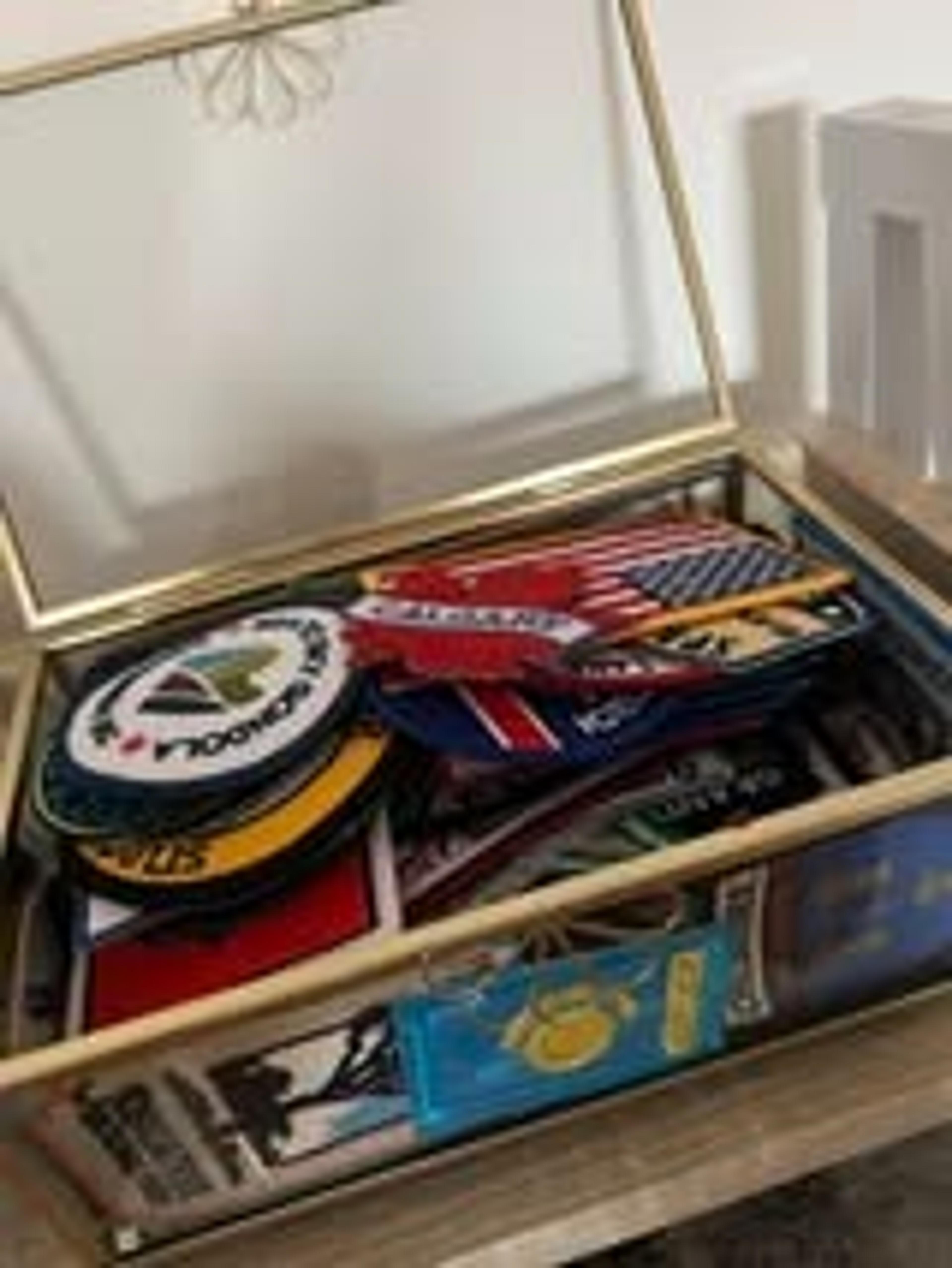 A glass box on a table holds a variety of travel patches, including one from Dulles Airport.