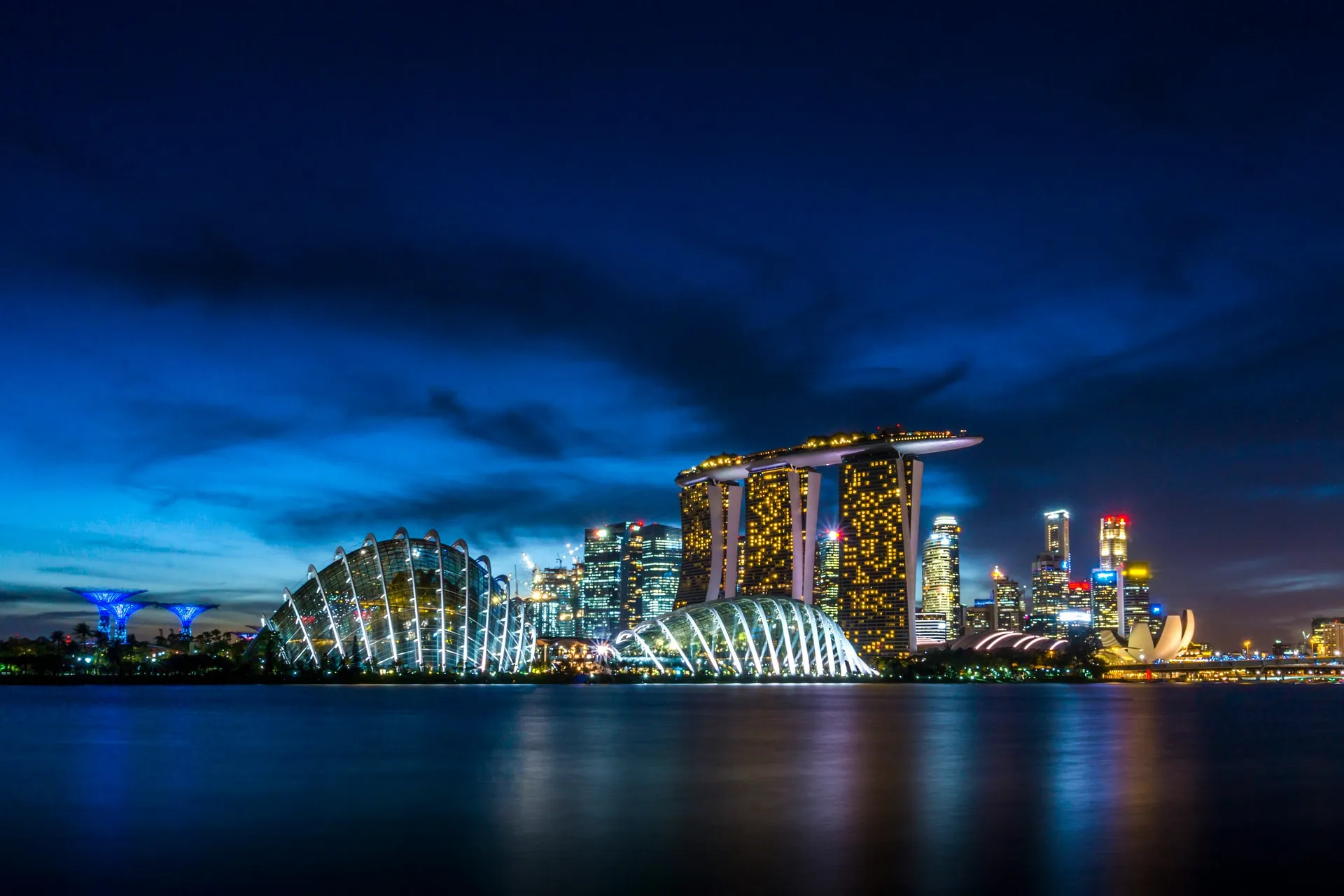 Marina Bay Sands and Gardens by the Bay beautifully illuminated at night in Singapore.