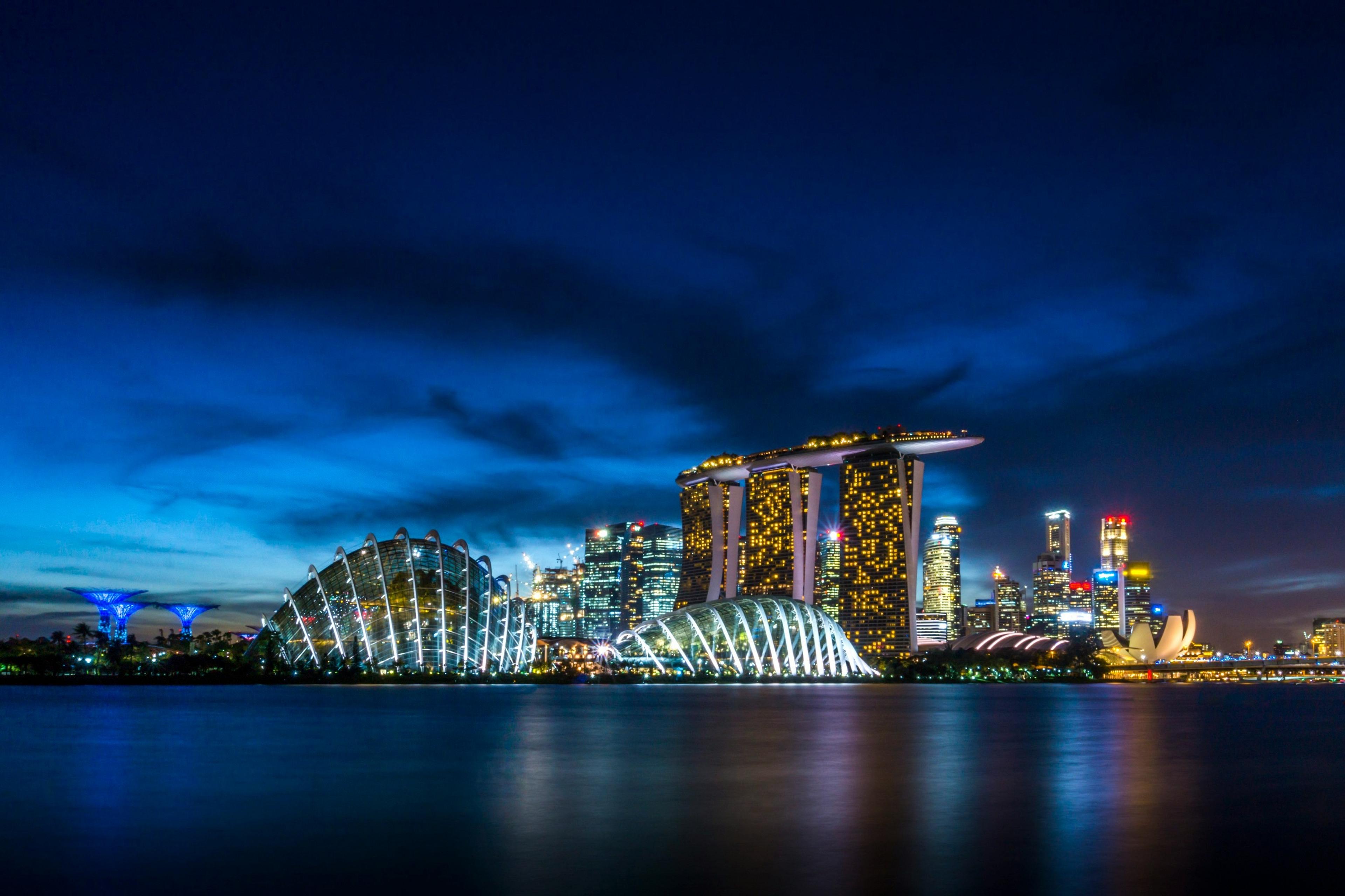 Marina Bay Sands and Gardens by the Bay beautifully illuminated at night in Singapore.