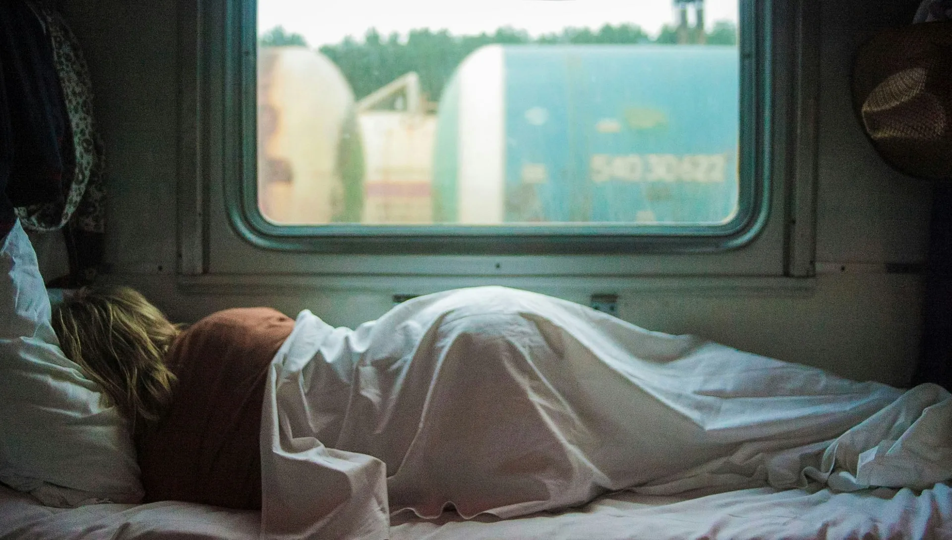 A person sleeps in a cozy train compartment