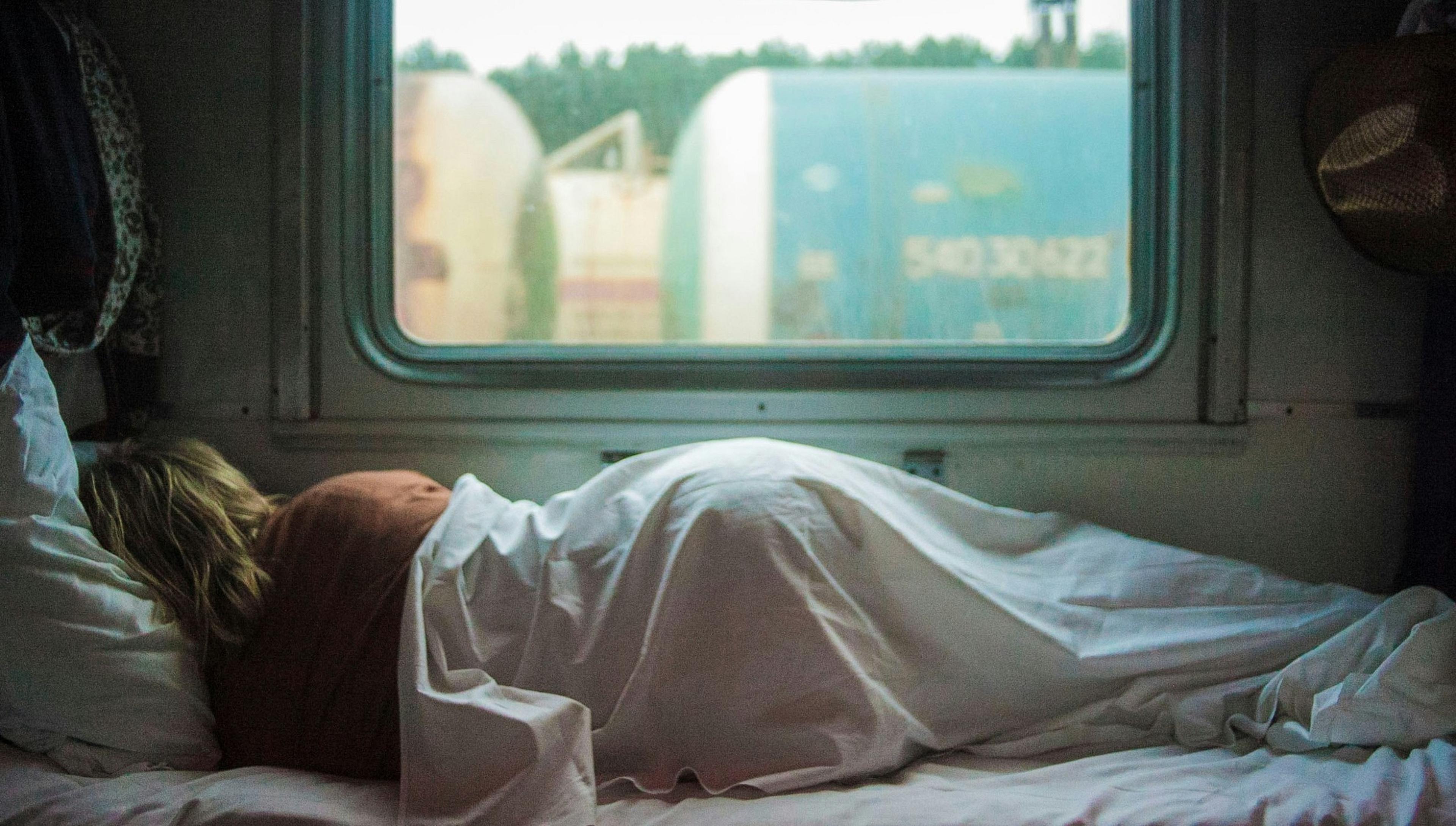 A person sleeps in a cozy train compartment