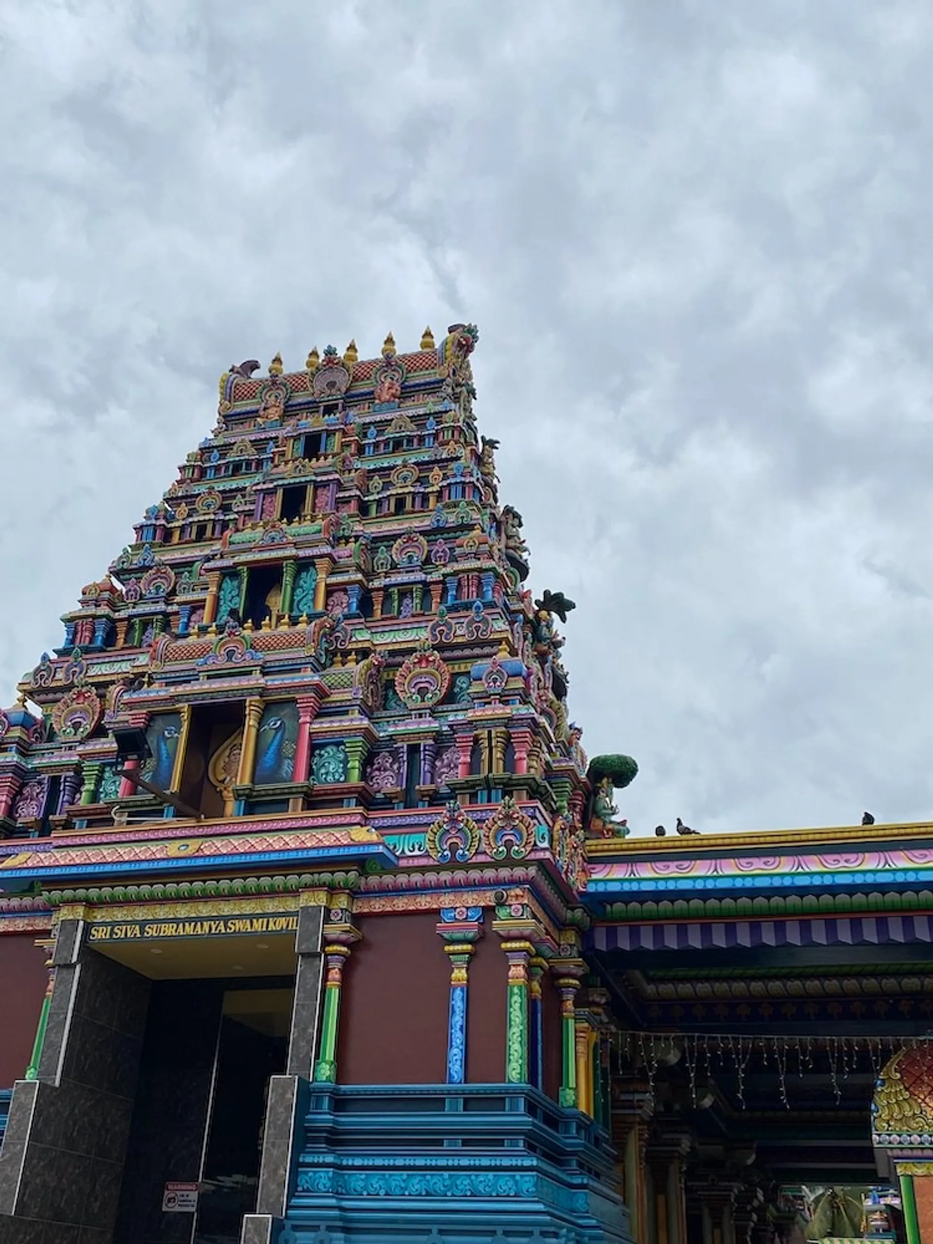 Vibrant and intricate architecture adorns the Sri Siva Subramaniya Temple in Nadi, Fiji, under a cloudy sky.