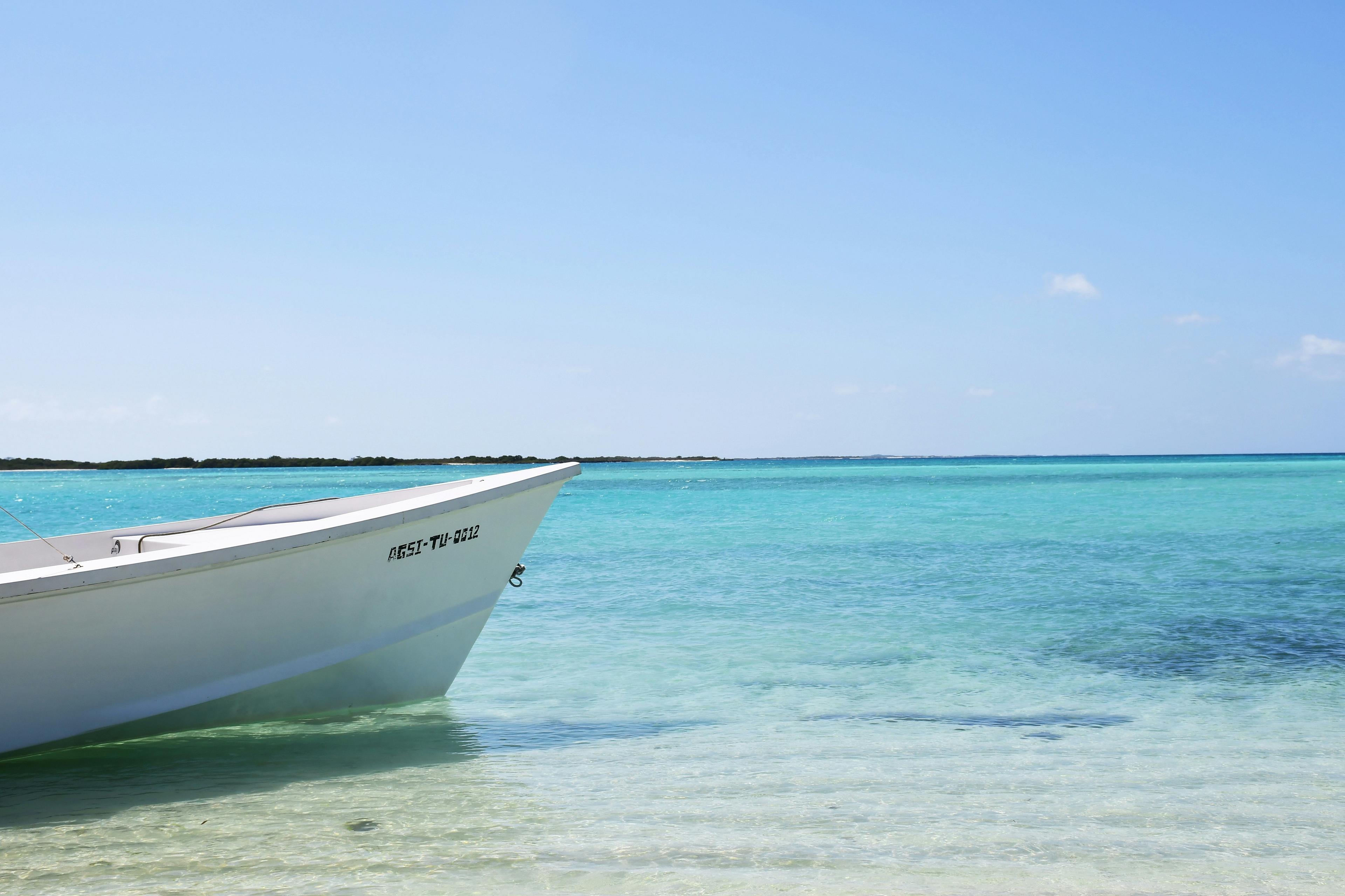 A white boat rests in the turquoise waters 