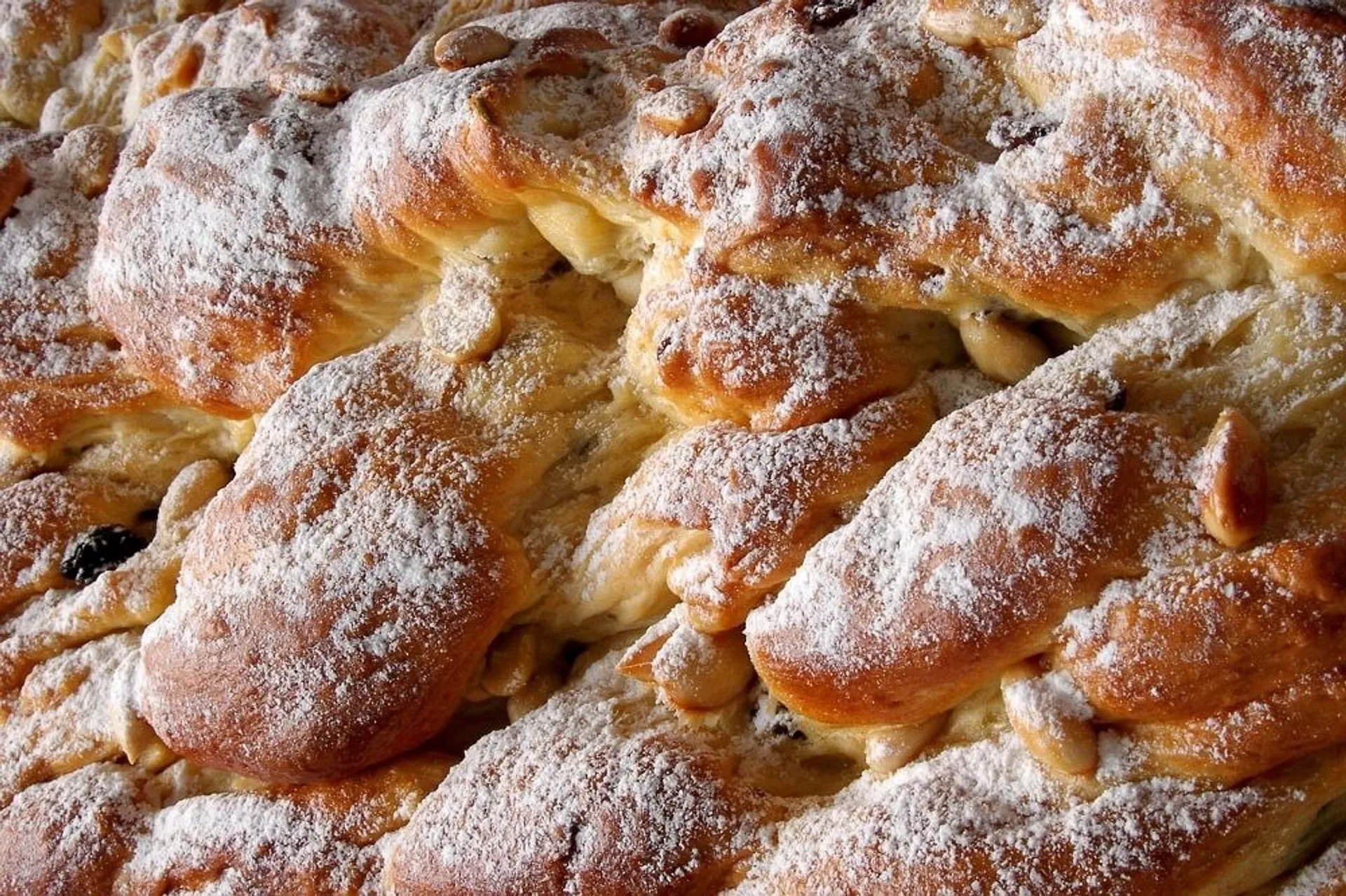 A close-up view of a freshly baked festive bread dusted with powdered sugar 