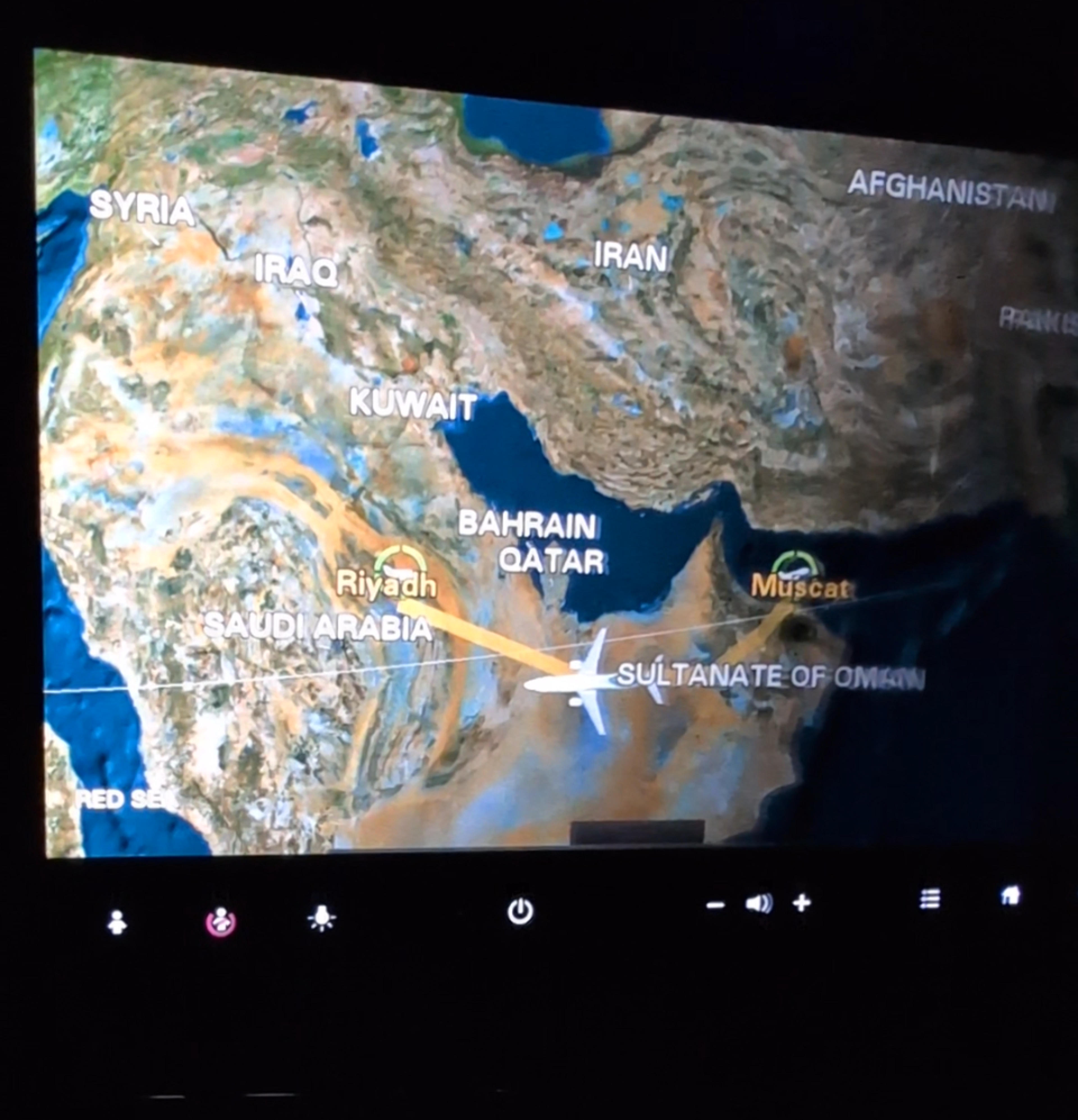 An in-flight map displays a plane traveling over the Arabian Peninsula, highlighting locations such as Riyadh, Muscat, and the Sultanate of Oman.