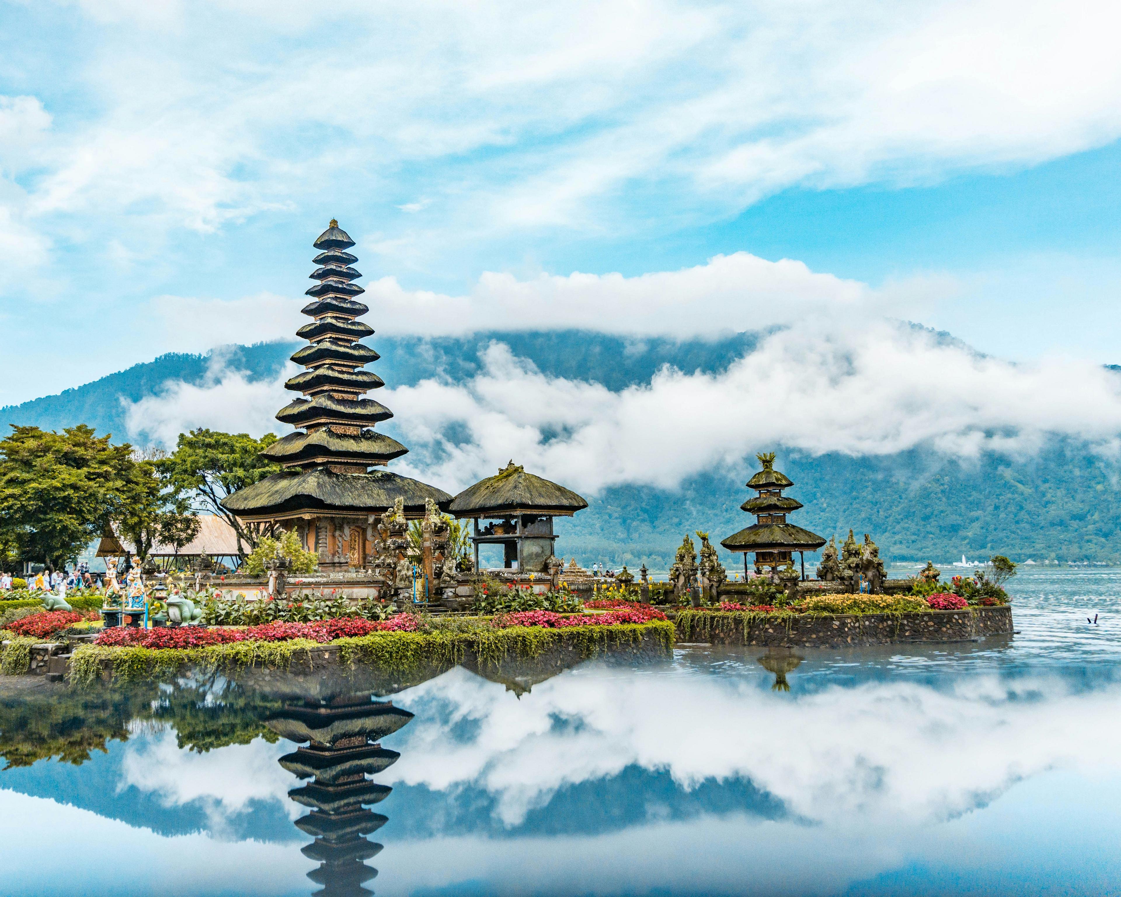 Temple by the water with mountain and clouds in the background