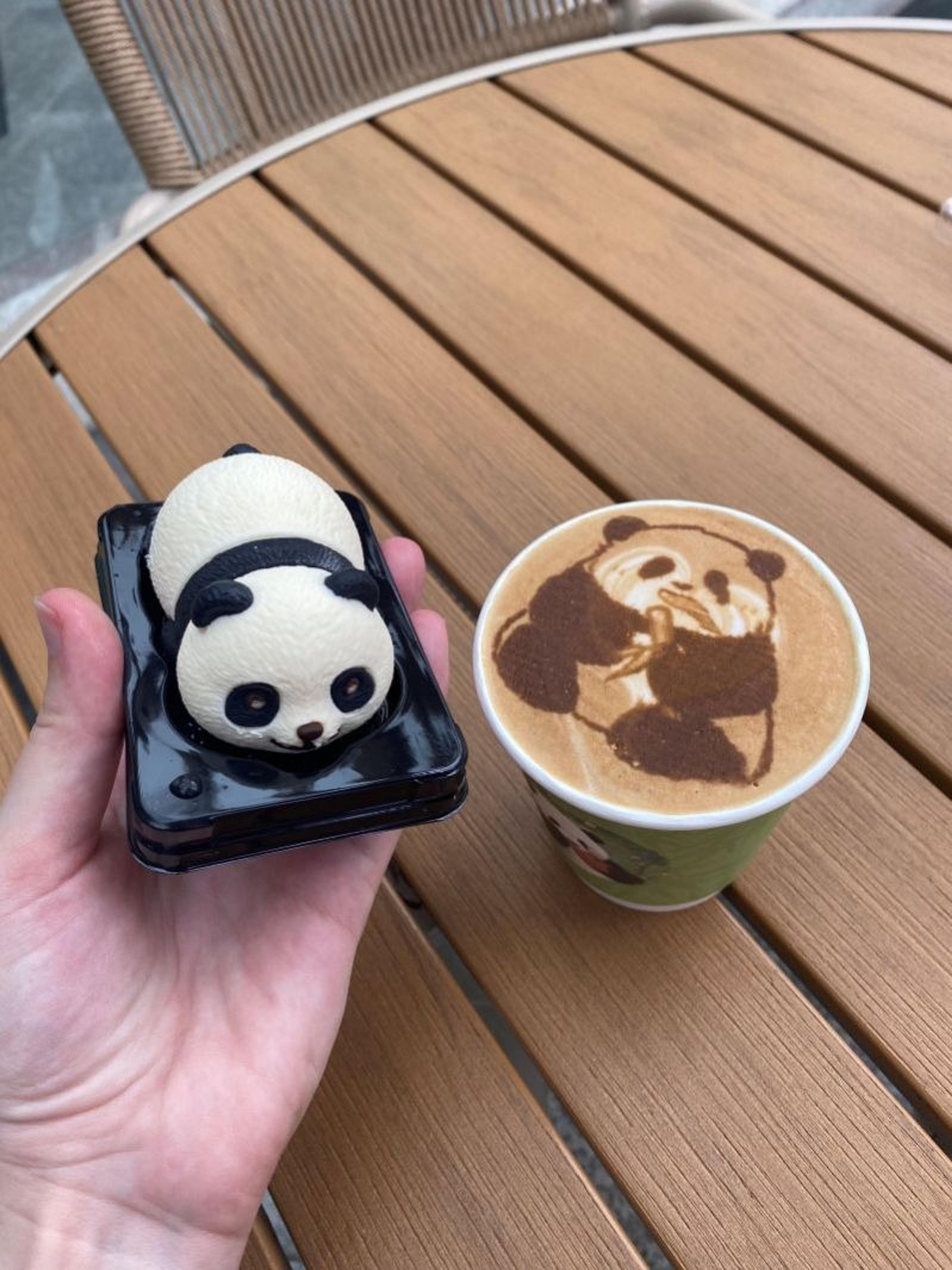 A panda-themed dessert and latte art are delightfully arranged at a wooden table settin in Chengdu