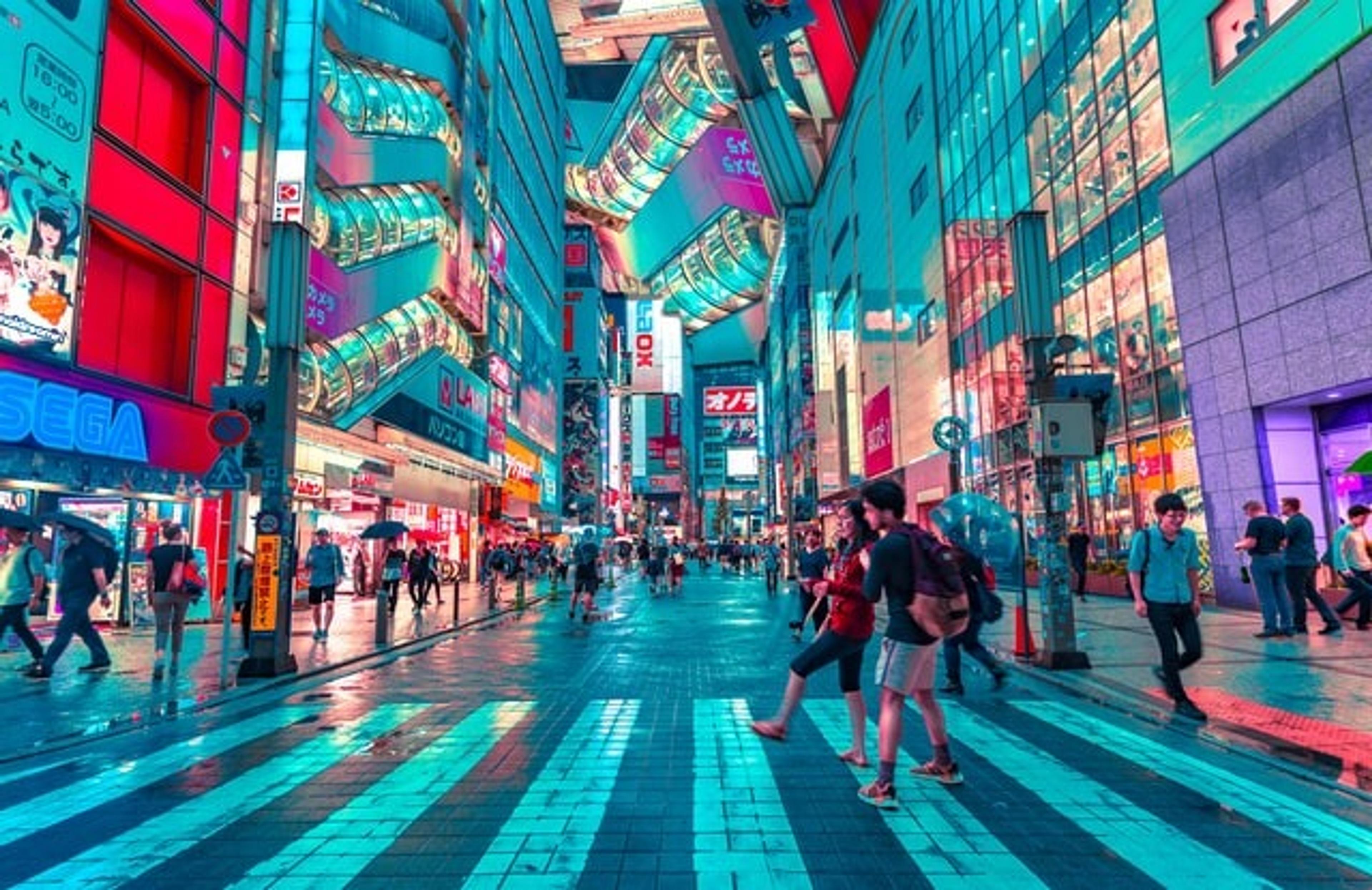A busy Japanese street surrounded by bright and colourfully lit buildings