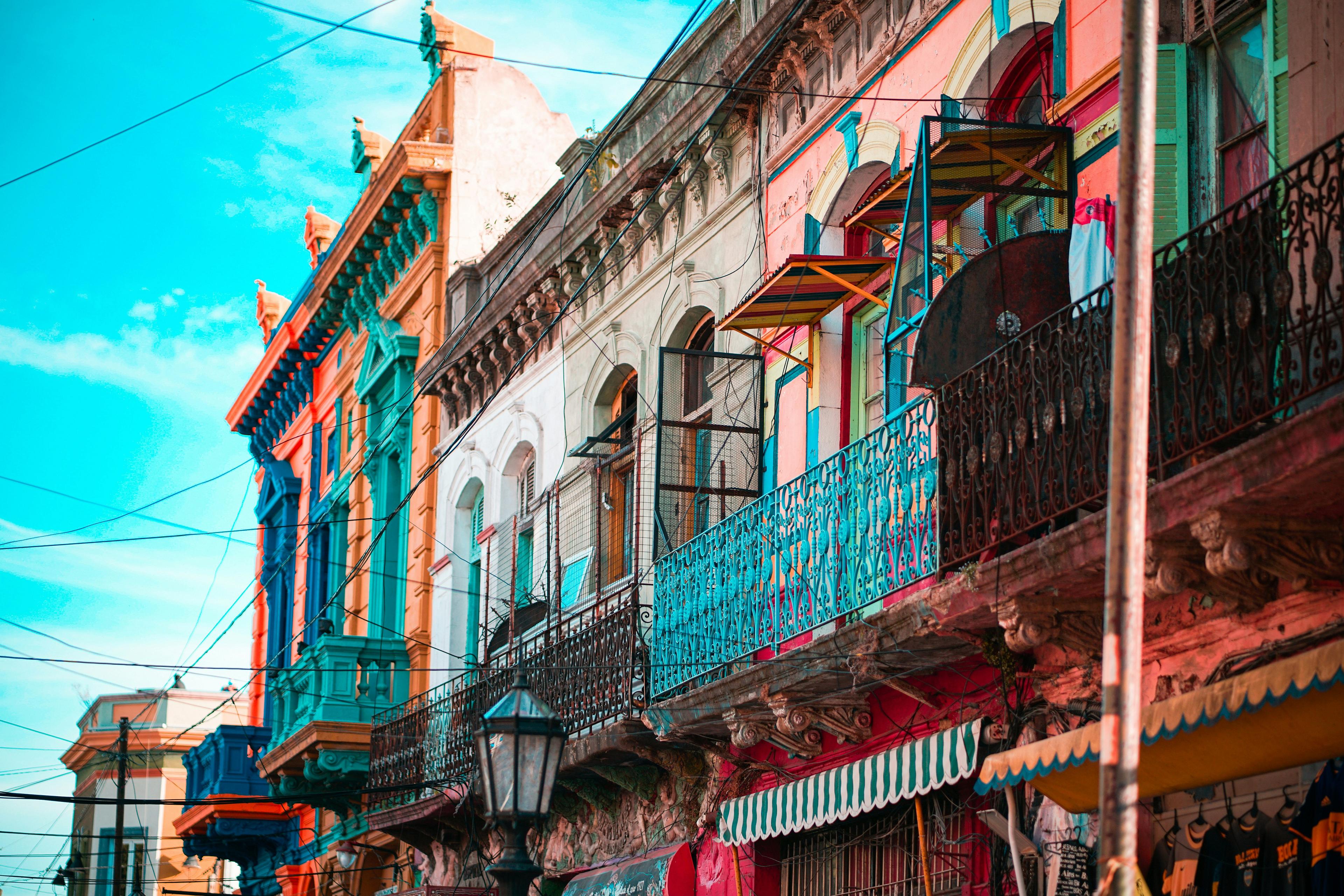 Colorful historic buildings with ornate balconies line a street in La Boca, Buenos Aires.